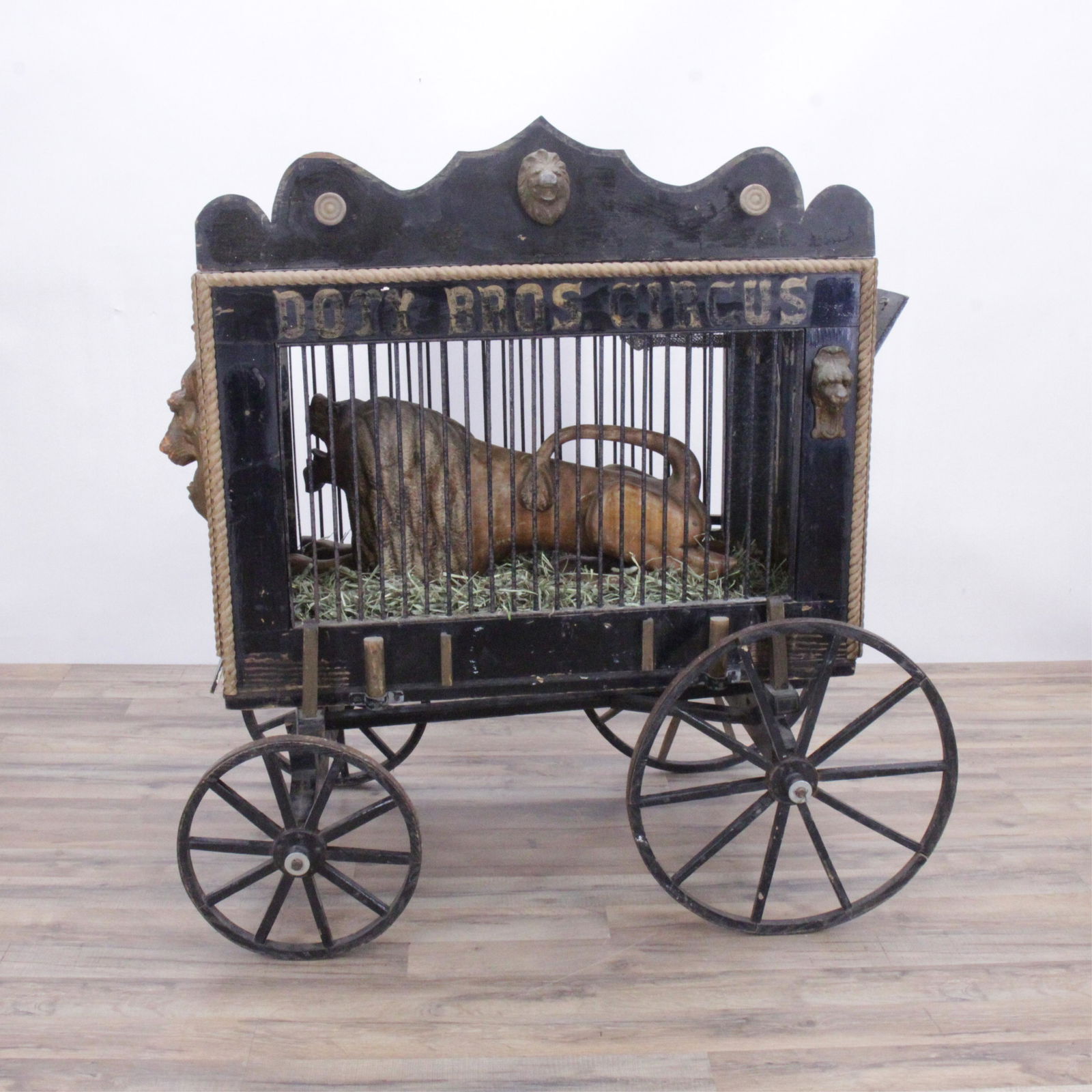 Doty Bros. Circus Lion's Cart & Folk Art Lion, E20: Doty Bros. Circus Black Painted Lion's Cart & Folk Art Lion, Early 20th C. (MST265)(MS) Dimensions: 47" H x 27" W x 45" L Property from a private collection, Scarsdale, NY.