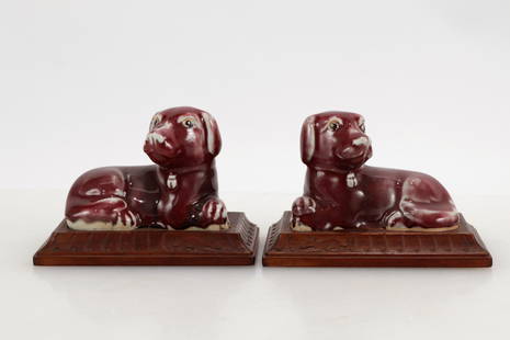 Pair of Chinese Porcelain Dogs: Pair of Chinese Porcelain Dogs, 20th C. Mirrored pair of a peach bloom style glaze, each on a simply carved bespoke wood stand. 4.25" H Property from the Estate of Marian Galewitz