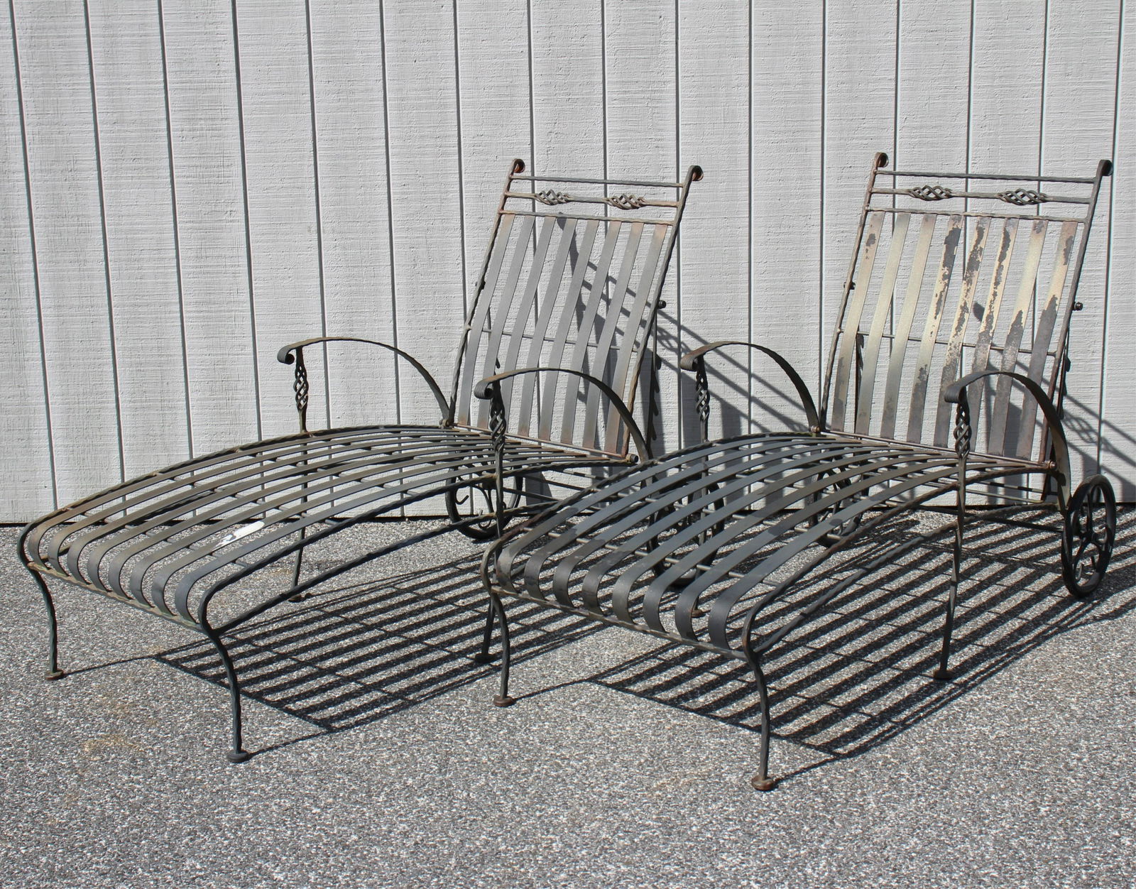 Pair Pool Patio Metal Chaise Lounges: Black metal painted chaises on wheels. 28" W X 64" L X "H Seat length; 50" min. to 81" laid flat. Property from a Fine Collection of Antiques & Decorative Art, Rumson, New Jersey.
