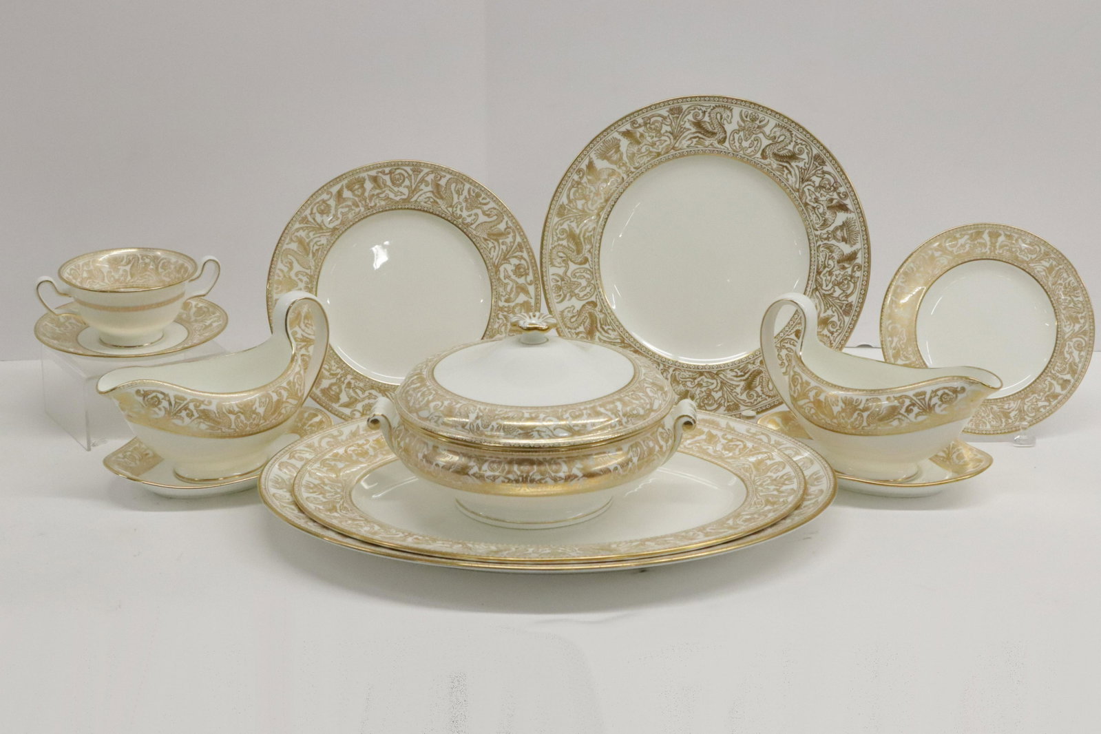 Wedgwood Florentine Gold Dinner Service: Wedgwood Bone China Florentine Gold porcelain dinner service including 8 dinner plates, 8 salad plates, 8 soup bowls with saucers, two covered vegetable tureens, two gravy boats with saucers, and two 