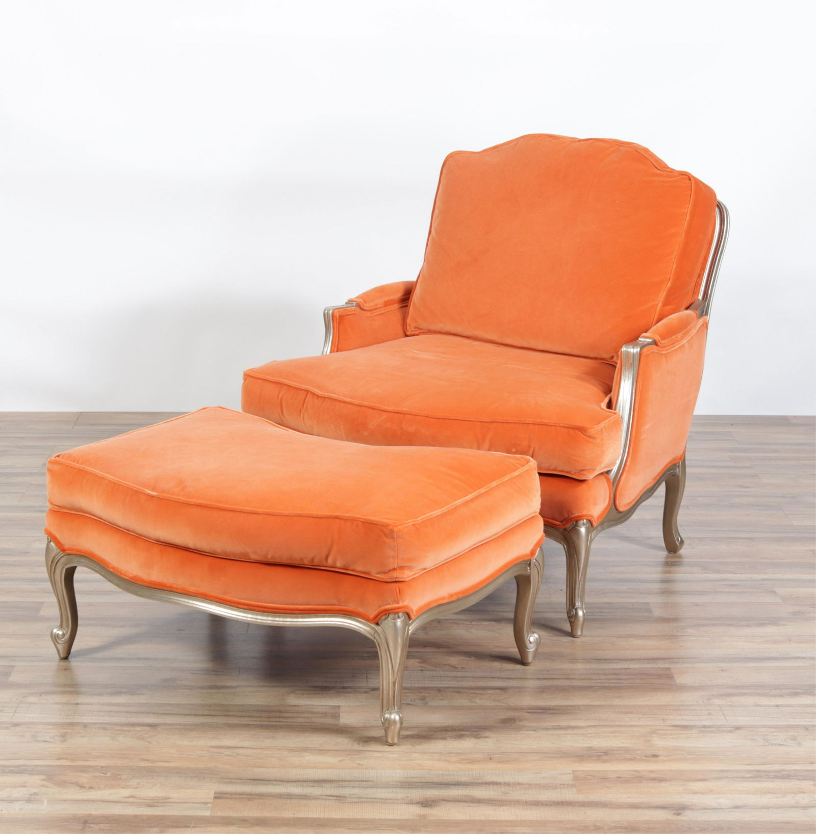 Ethan Allen French Style Bergere and Ottoman: Orange upholstery with toned silver painted wood frame. Zippered seat and back cushions.Dimensions: 33"W x 39 deep overall x 34.5H seat 18H Ottoman 32 x 22 x 16H