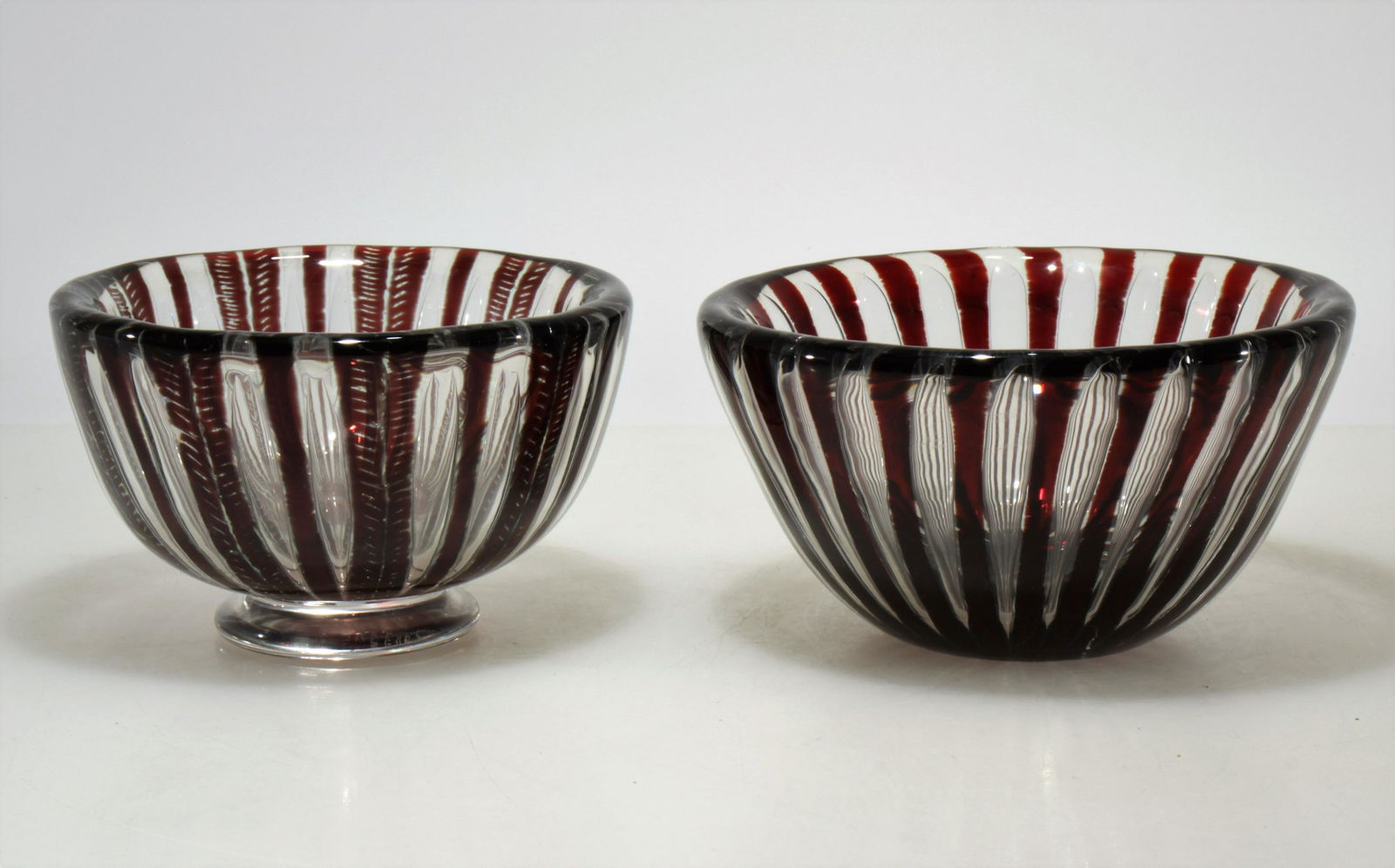 Edvin Ohrstrom for Orrefors - Two Ariel Bowls: Edvin Ohrstrom (Swedish, 1906 - 1994) for Orrefors - two Ariel bowls in clear and maroon coloring. Each signed on bottom. Dimensions: 3.75" H x 6.75" diam and 6.75" H x 6" diam. Property from the Esta