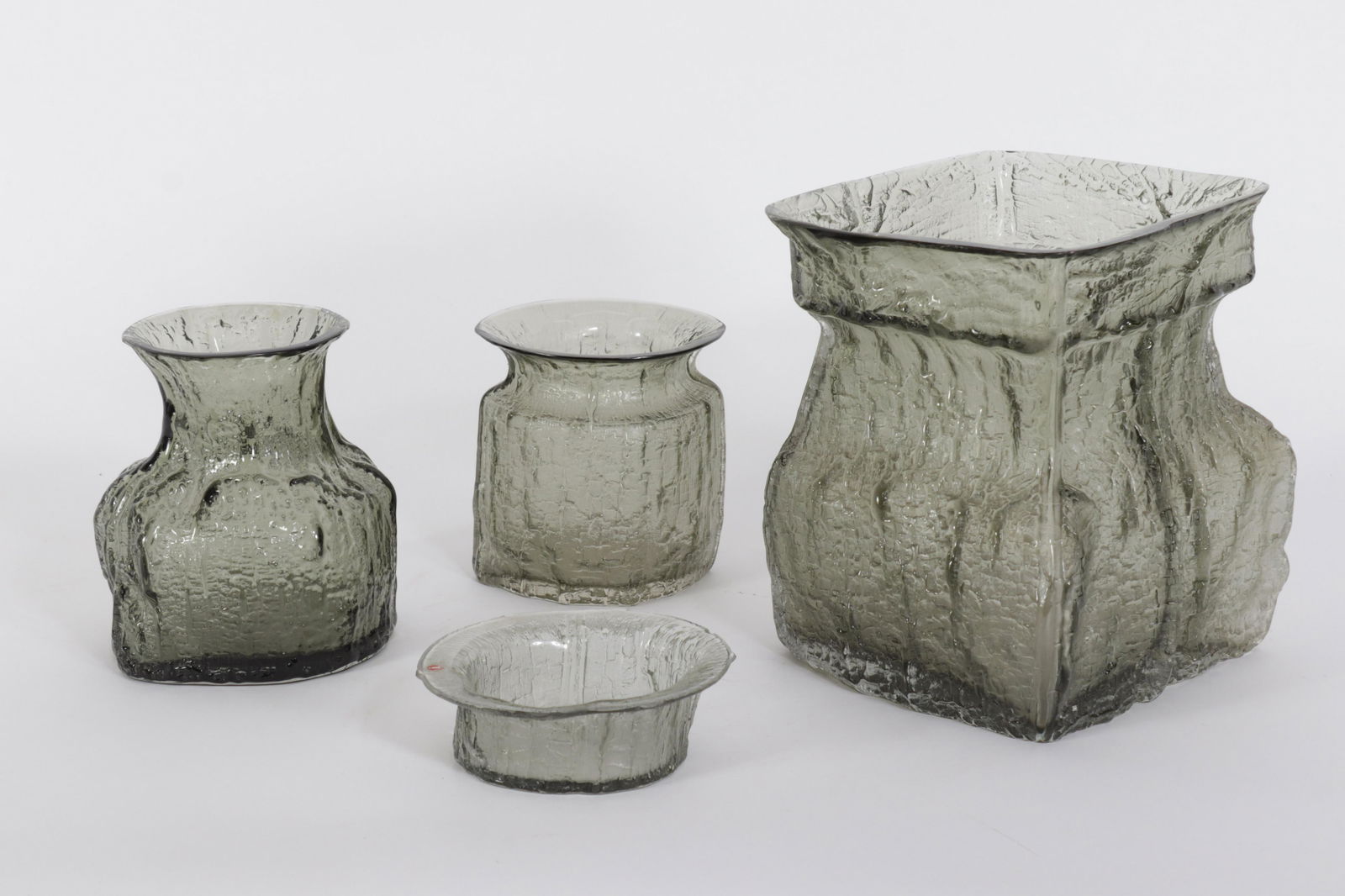 Timo Sarpaneva for Iittala - Vessels: Timo Sarpaneva for Iittala, four grey smoked glass vessels. Each signed on bottom. Dimensions: Largest: 9.25" H x 8" sq Property from the Estate of John 'Parker' Prindle, Jr., Boston, MA.