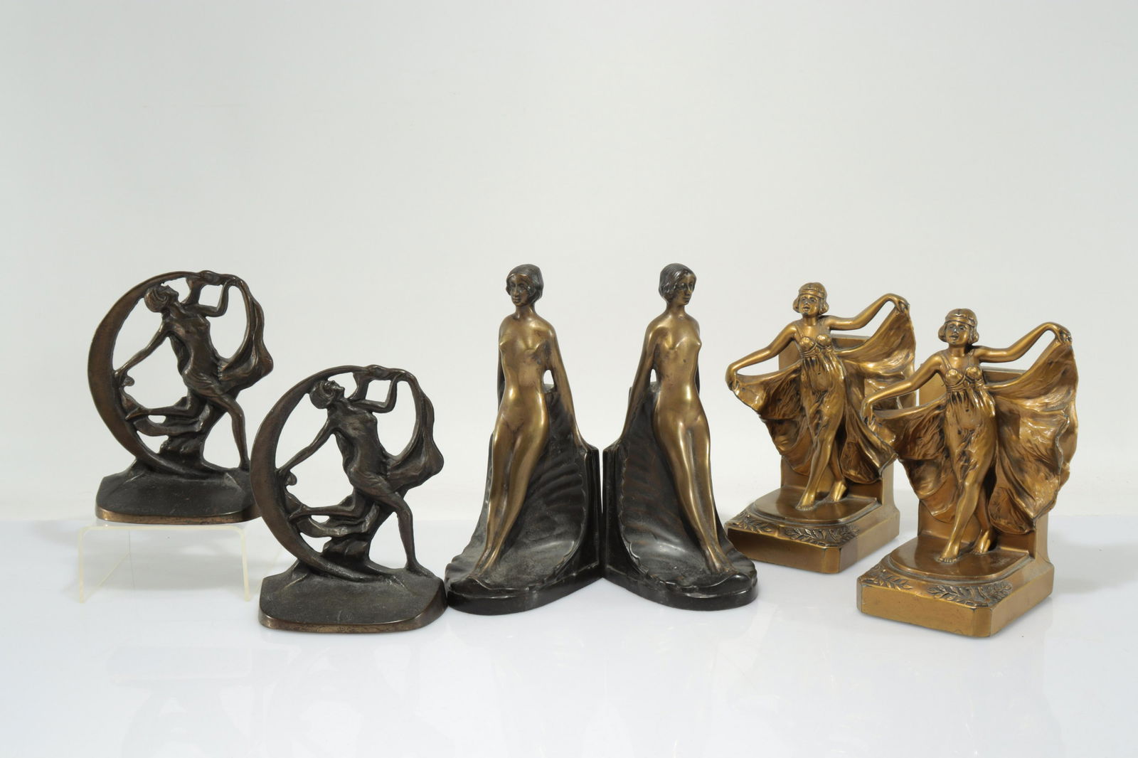 Three Pairs of Vintage Female Figural Bookends: Bronze Deco nude dancer with crescent moon C1930 by Creation Co. Cast and patinated metal Flapper dancer marked 500 and woman in standing repose. Dimensions: Dancer with moon 6"H x 4.75W x 2. Standing
