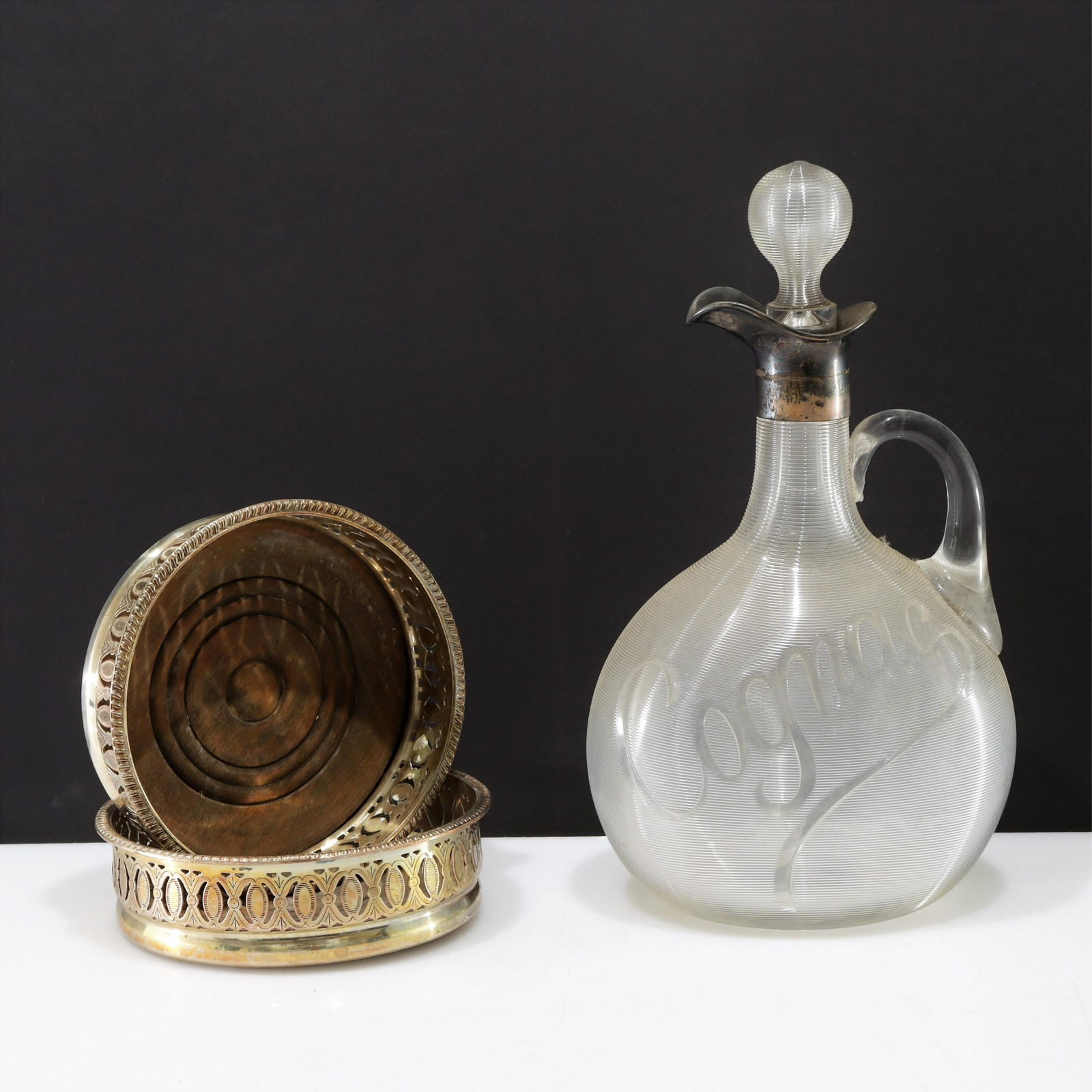 English Silver Mounted Decanter & Wine Coasters: English Silver Mounted Etched Glass Decanter & 2 Wine Coasters, marks Walter & Charles Sissons, Late 19th C. Dimensions: Cognac 10" HCoasters 5.25" Dia. Property from the collection of Seymour Stein.