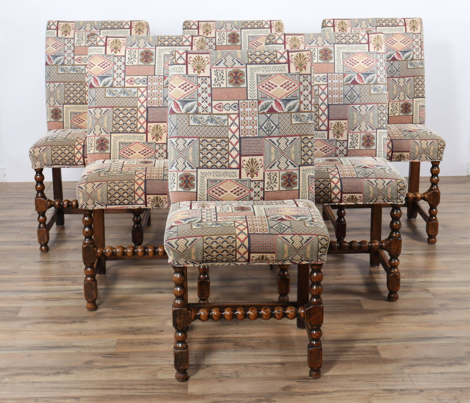Six Tudor Dining Chairs: Six Tudor Oak Dining Chairs, bobbin and block turnings, upholstered seat and back in patterned chenille fabric Dimensions: 39"H x 19 1/2"W x 24"D, seat height and depth 20 1/2 x 15 Property from a Man