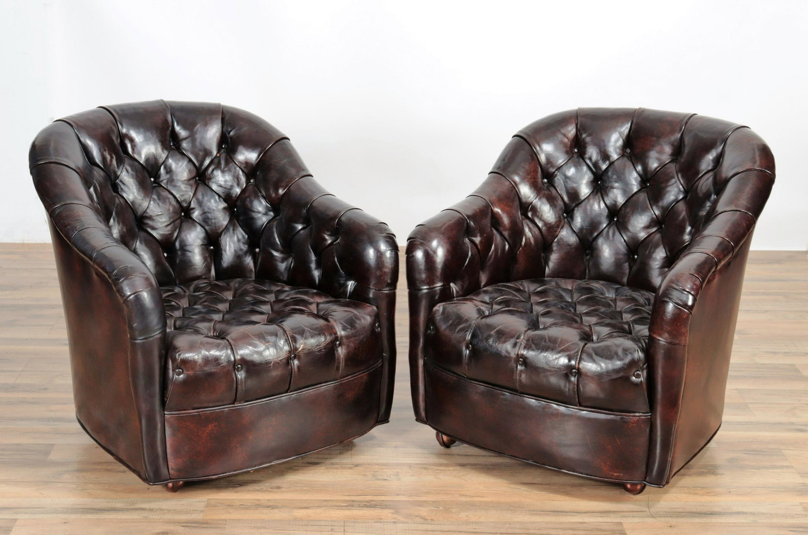 Pair Leather Upholstered Club Armchairs: Pair Leather Upholstered Club Armchairs, upholstered in buttoned brown leather Dimensions: 29.75" H x 28.5" W x 31" D Property from the estate of an esteemed archaeologist and scholar, Princeton, NJ.