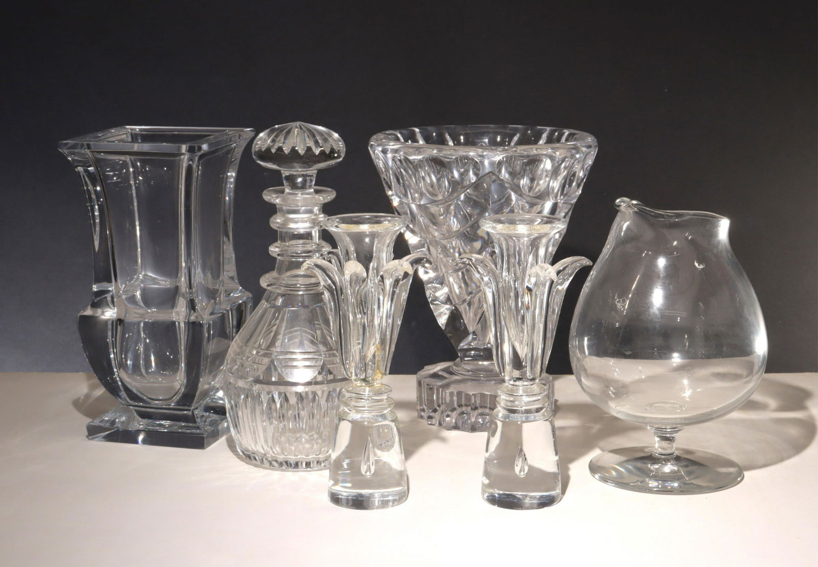 Steuben, Baccarat, Sevres Royal Brierley Crystal: Group of Crystal Crystal vases, candle stands and decanters includes a Baccarat decanter, Sevres Cristal France Vase, an unmarked triangular vase, a pair of Steuben Versailles by Donald Pollard candle
