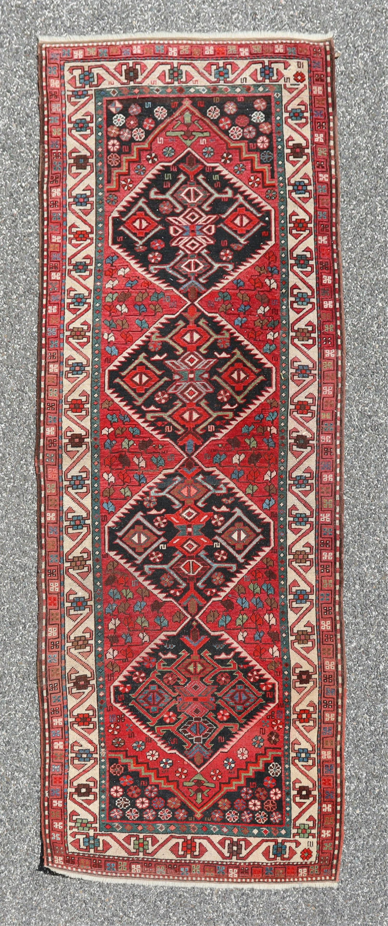 Shiraz Wool Runner 3-6 x 8-10: Shiraz wool runner field with red ground with four central medallions of geometric form followed by floral forms multiple borders with geometric forms, colors include dark blue lighter blue and green 
