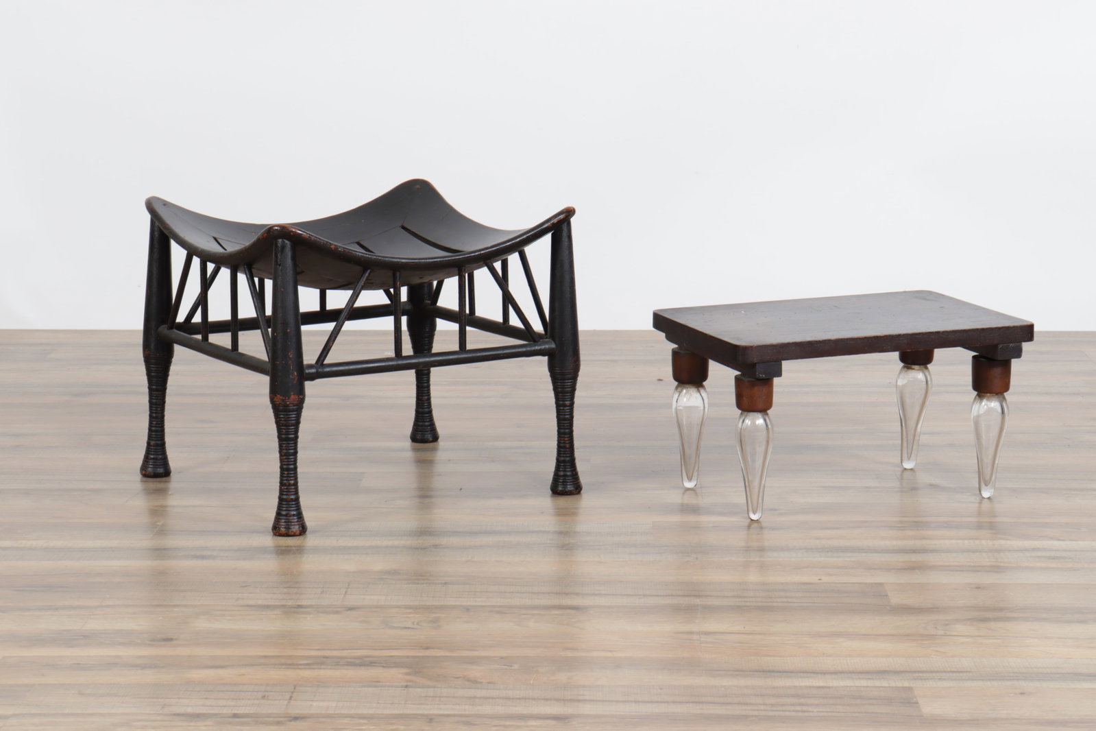 Thebes Footstool & Seat with Glass Legs: Thebes Black Wooden Footstool along moth a wooden seat with glass legs. Note: Arnold and Dora Stern were collectors of Outsider, Tramp and American Folk Art, Cuban and Haitian art. A portion of their 
