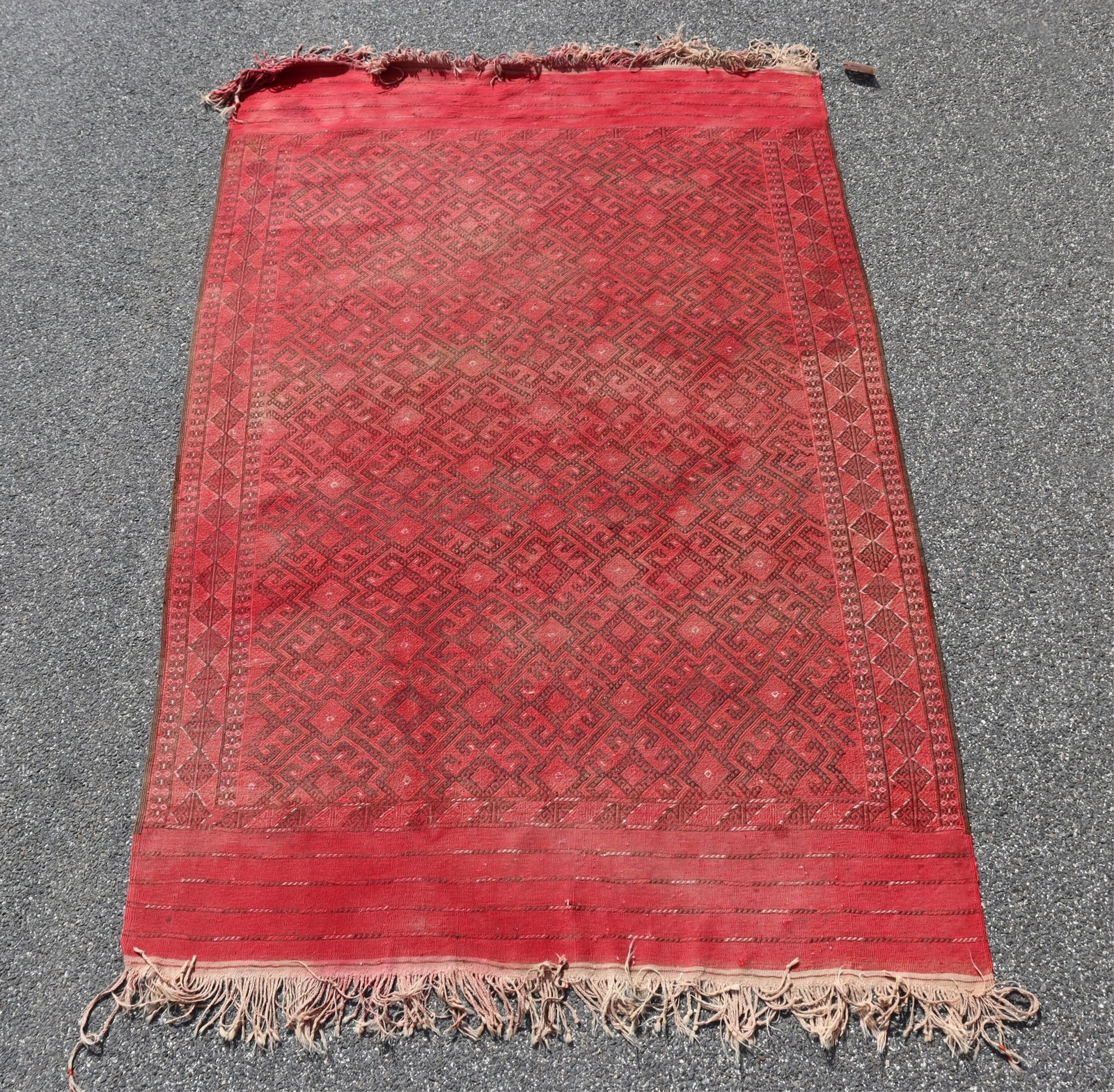 Turkish Kilim 6-7 x 10-4: Overall salmon red with brown repeated geometric patterning. Wide horizontal banding to fringe ends. Vertical side bands. Long braided fringe. 6-7 x 10-4