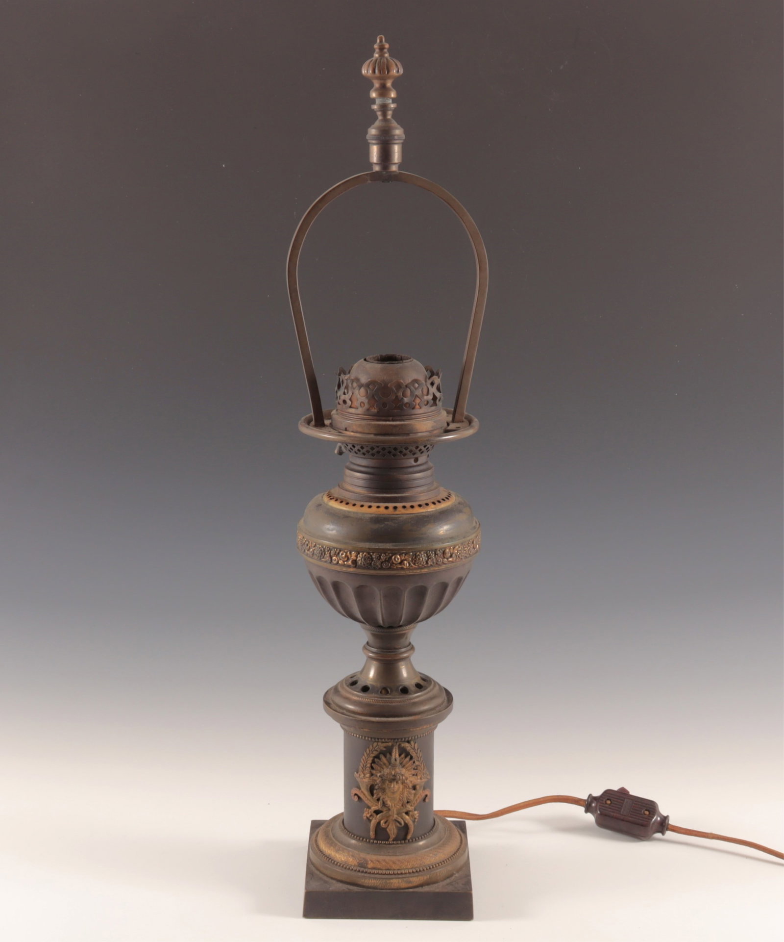 Brass Oil Burning Lamp: Brass oil burning lamp now electrified. No globe. Brass Deity on base. 22" H to finial