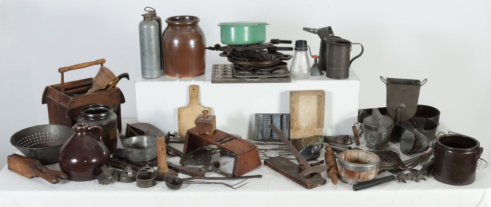 Antique & Vintage Kitchen Tools, Pans, Stoneware: Large collection of antique and vintage kitchenware, includes lamb bone holder, waffle irons, sifters, muffin molds, cheese mold, pans, colanders, graters, nutcracker, utensils, stoneware jug and iron