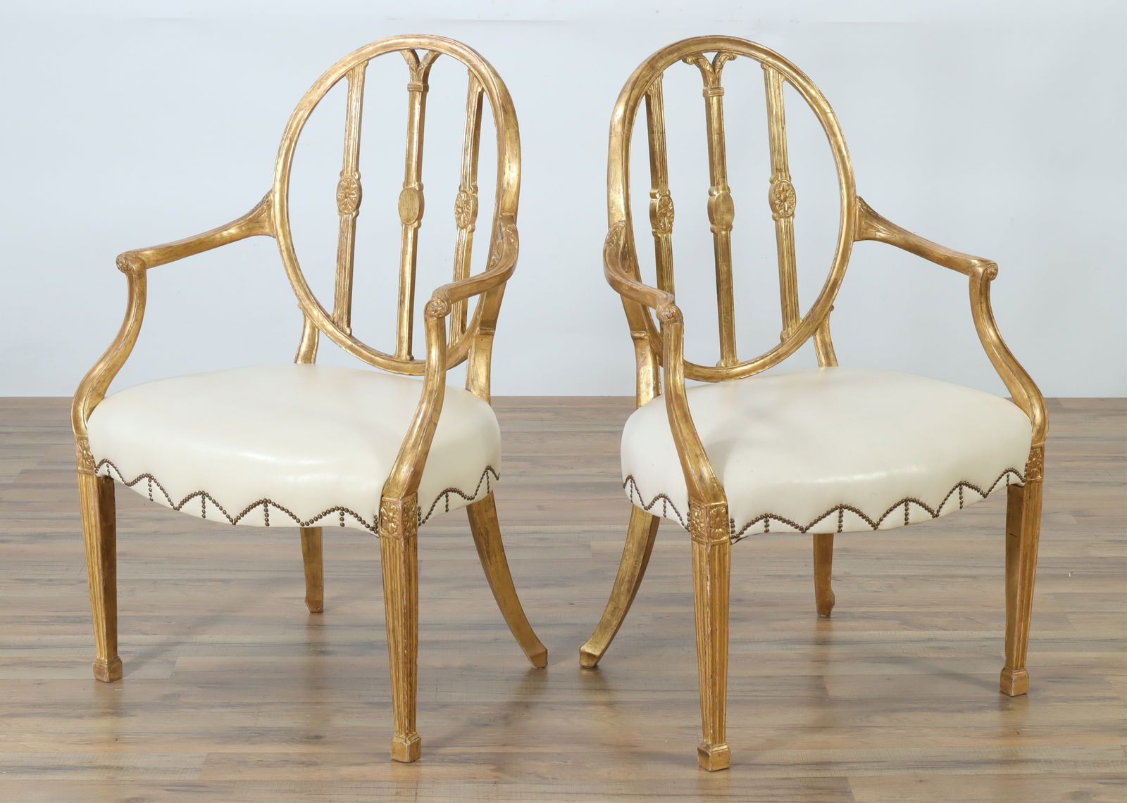George III Giltwood Open Armchairs, c.1780: Pair George III Giltwood Open Armchairs, circa 1780, upholstered in cream brass tacked leather38.25" H x 24.75" W x 22.5" DProperty from a renowned fashion executive, Washington, CT.