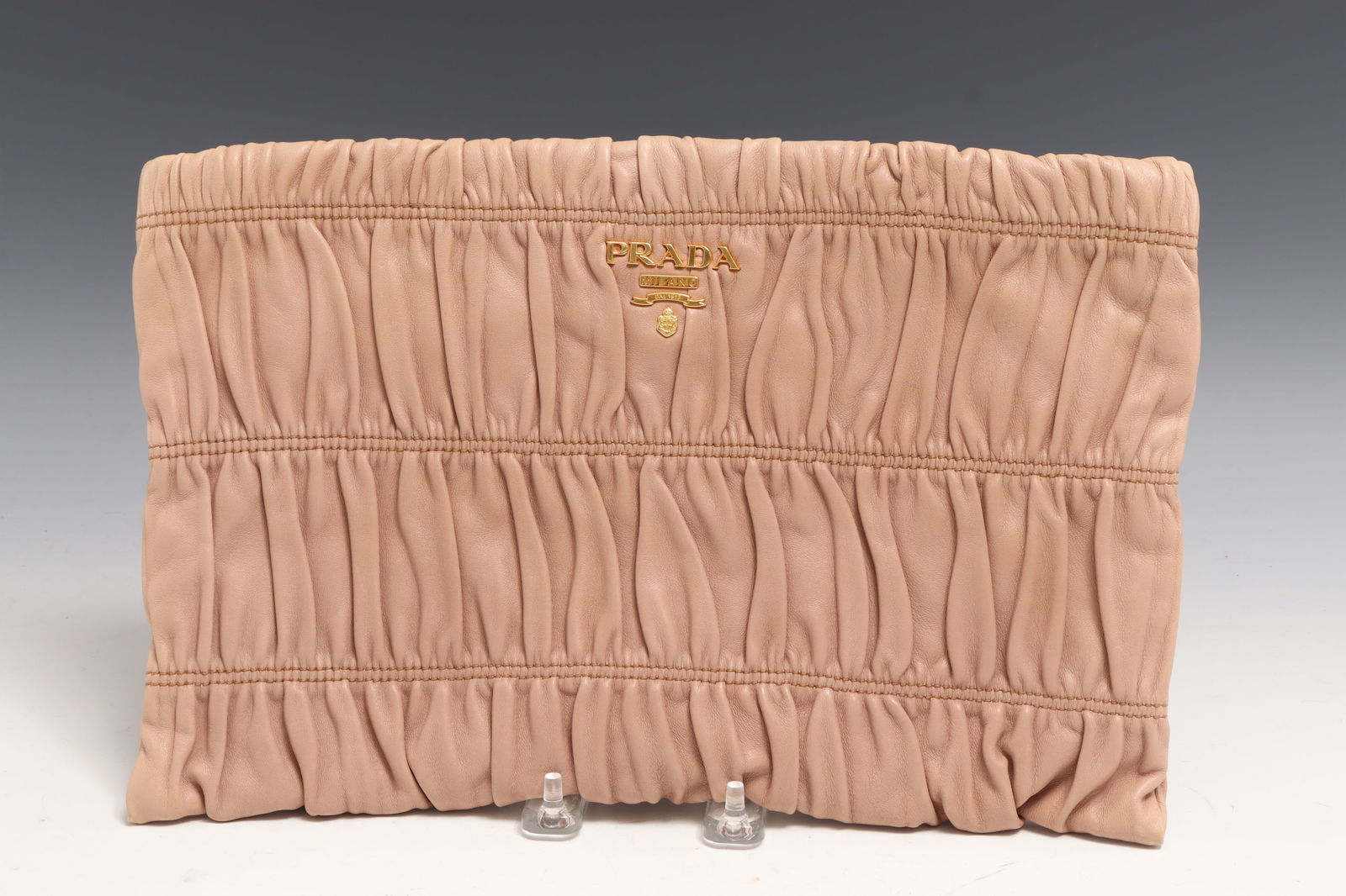 Vintage Prada Nappa Gaufre Clutch: Vintage Prada Nappa Gaufre Clutch. Nude/tan pleated exterior, leather interior with two slip and one zip pocket, gold tone hardware. 8" x 13" Property from a Connecticut collection