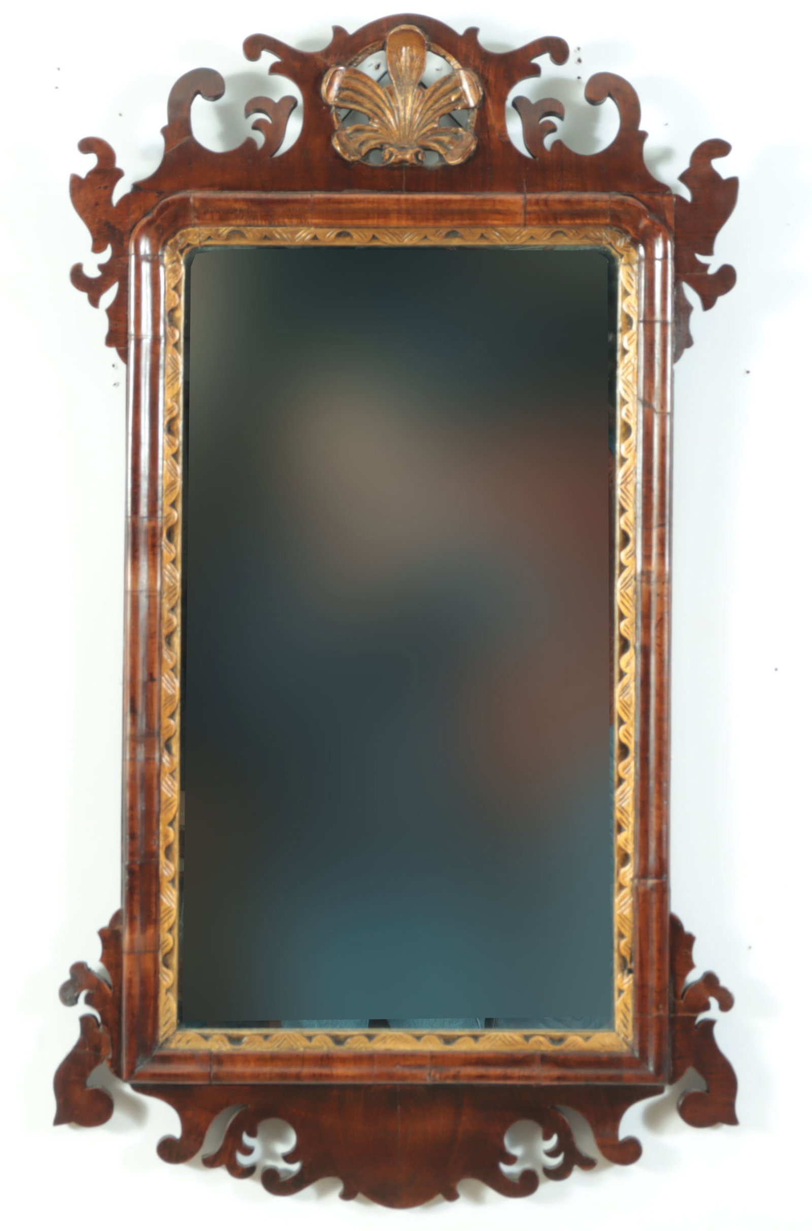 George III Carved Parcel Gilt Pier Mirror, 18th C: George III carved and parcel gilt walnut veneered pier mirror, 18th Century, with gilt liner and shell, and scrolled frame. 34 1/2" x 19 3/4" Property from the estates of Thomas Johnson Hubbard and An
