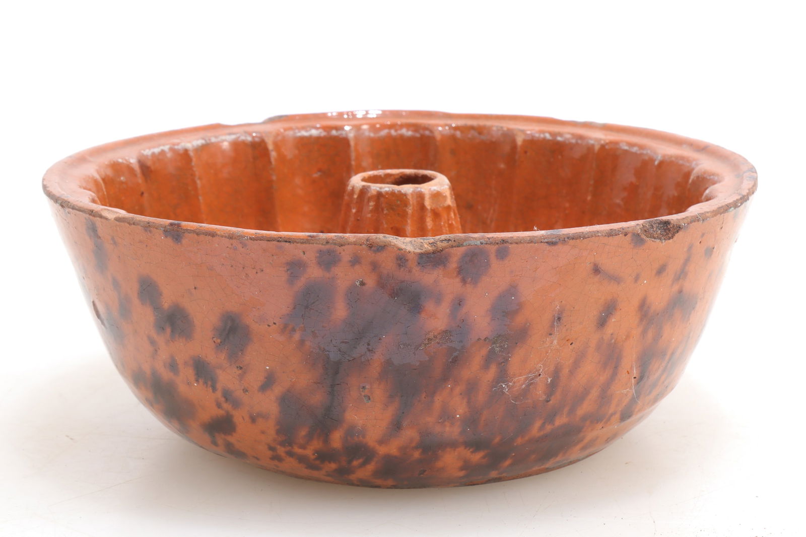 Redware Bundt Pan, PA, 19th C: Glazed redware bundt pan, Pennsylvania, 19th Century, with mottled red/brown glaze and ribbed interior. 2 1/2" H x 7 1/2" Dia Property from the Estate Collection of Jeff Trundy, Washington, CT and Aug