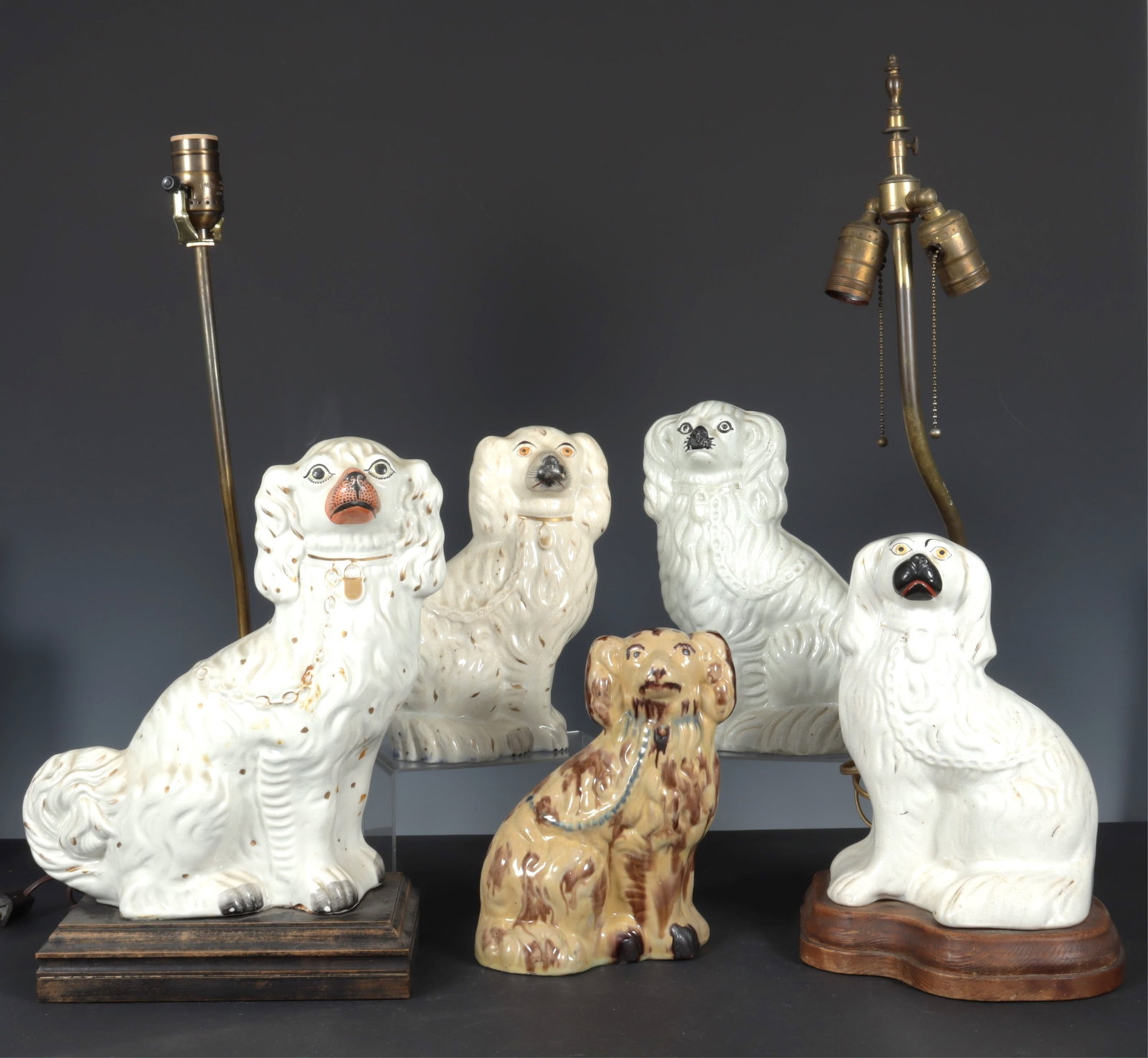 Five Staffordshire Pottery Spaniels: One early version in browns with blue collar, leash. (2) mounted as lamps, wood bases. eg: 12.5" x 11.5" x 4.5". Taller" lamp 14.5"H; with base 22.5 overall. Tanware dog 9" H x 7" W x 3.5"D Property f
