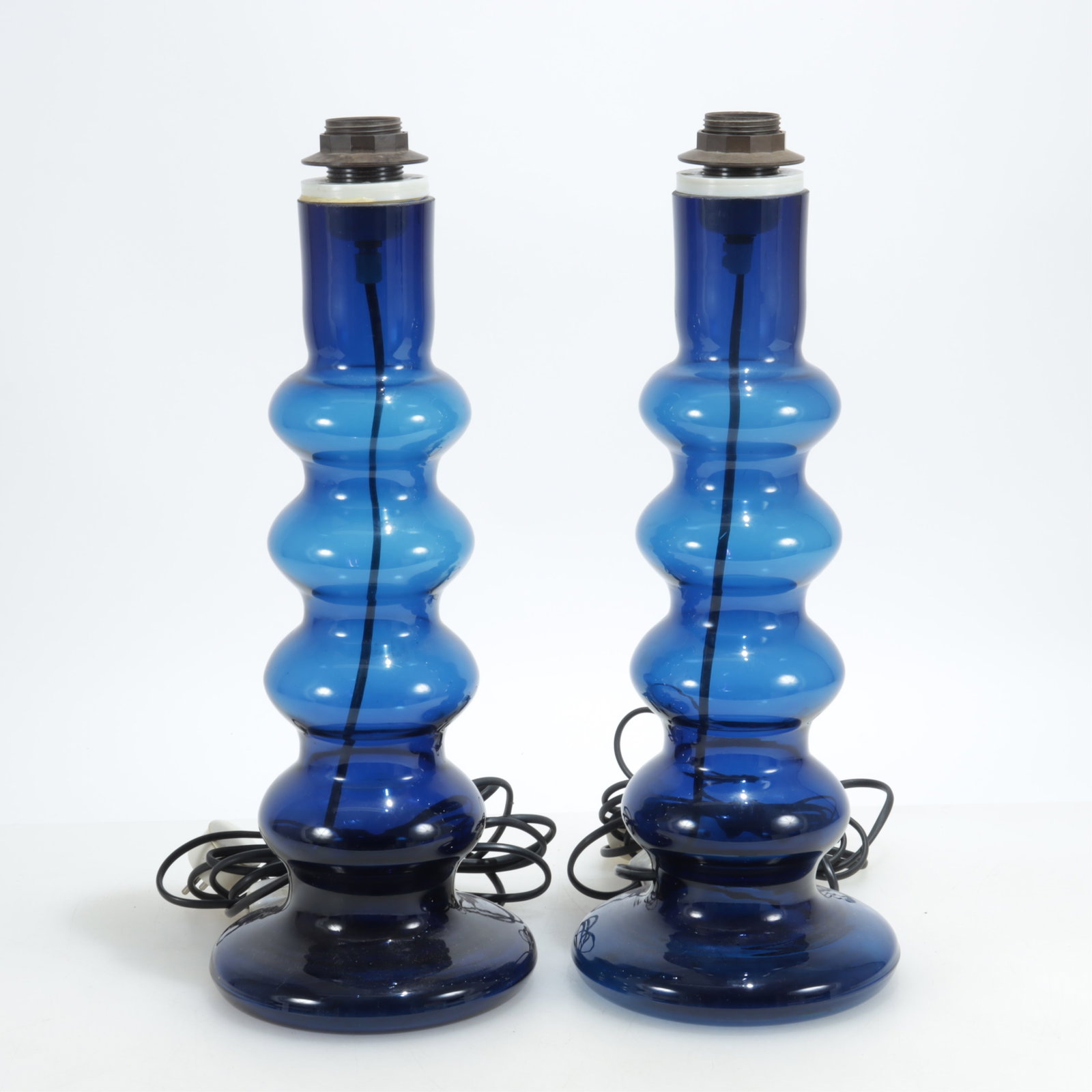 Pair Blue Glass Table Lamps, Poss. Lexus: Pair of wavy blue glass table lamps, possibly Lexus, c. 1960-70, euro plug 16 1/2" x 7", Top of socket 18 1/2"