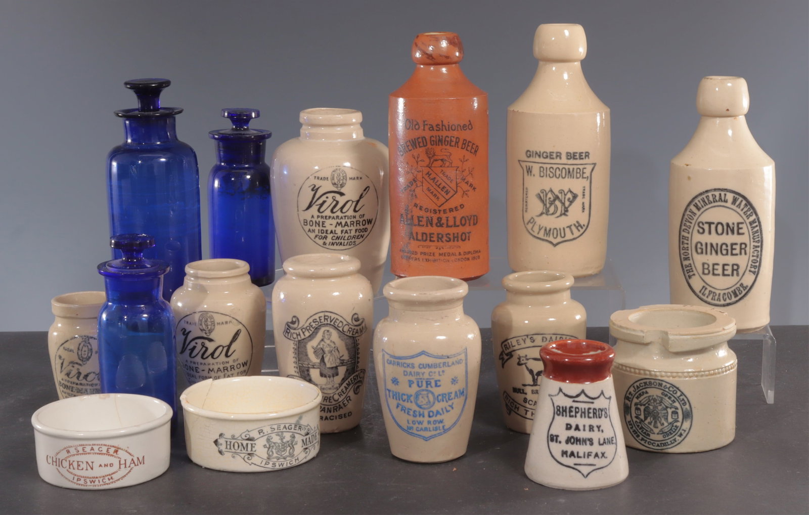 Antique English Stoneware Food Jars: (13) stoneware and (3) cobalt blue glass fitted stoppers apothecary bottles. Includes (3) Ginger Beer bottles, Virol Bone Marrow, Jackson Caviar, Dairy Cream. Ginger beer 6.75"H Virol Bone Marrow 5.5H