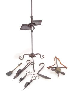 Assorted Iron Lamp & Tools: A wrought iron tripod lamp with dual reserve tray, hook handle and scrolled feet, together with three wick trimmers, 1 pot lifter and a pump drill with leather cord; together with an ember shovel engr