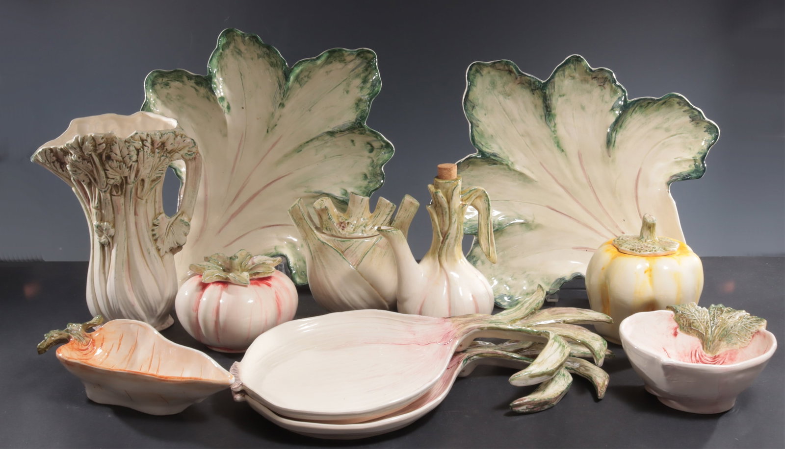 Vietri Vegetable Dishware: Vietri vegetable-form dishware, Italian, 20th Century, comprising: 2 cabbage platters (16 1/2" x 15"); 2 onion platters (17 1/4" x 9 1/2"); 1 carrot dish (11" x 4 1/2"); 1 garlic cruet (8 1/2" H); 1 c