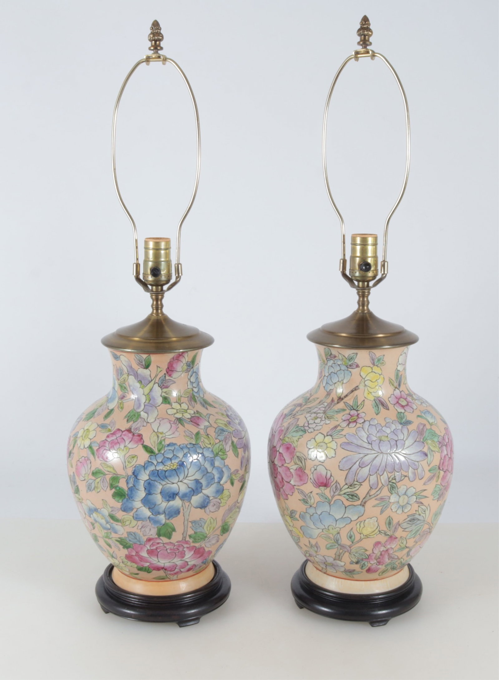 Pair of Chinese Style Porcelain Lamps: Pair of Chinese Style Porcelain Lamps. Salmon color ground with floral motif, affixed to wooden stands. 29" H to the finial