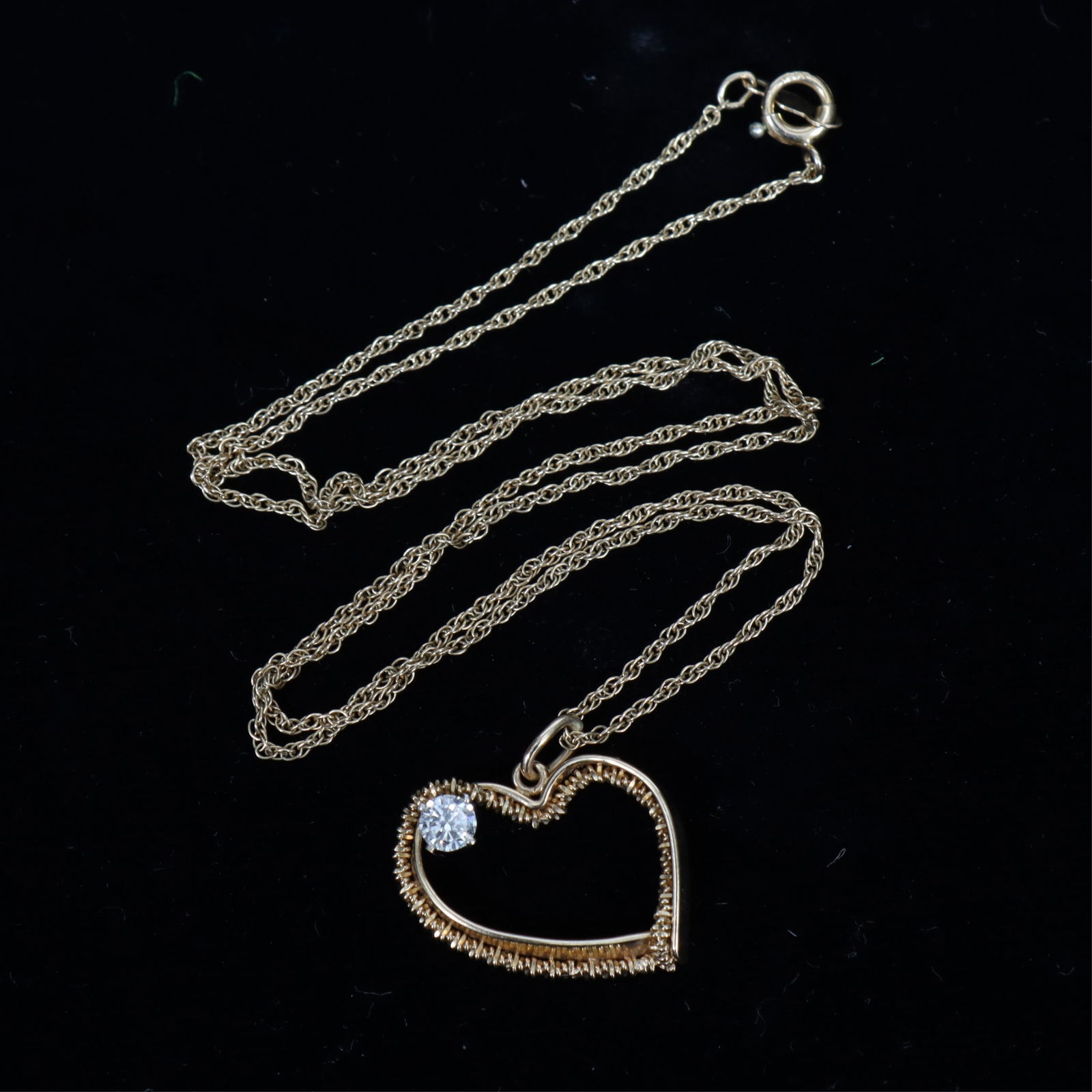 14K Yellow Gold and Diamond Open Heart Necklace: A vintage 14k yellow gold open heart pendant with round brilliant cut diamond, suspended from a 14k yellow gold rope chain. Top of heart stamped 14K with maker's mark and patent number, chain clasp st