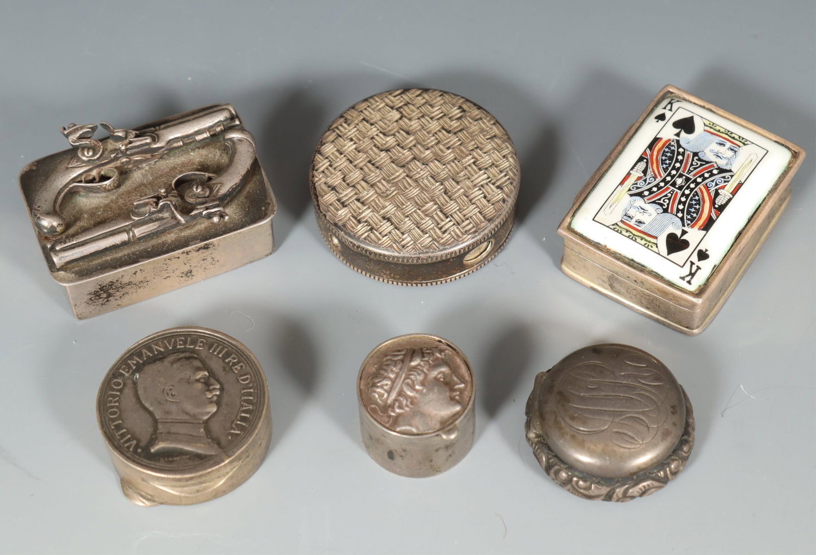 Group of Silver Boxes: Group of Silver Boxes. Comprising: round sterling basket weave, .800 reproduction Lire coin box, sterling round floral repousse, sterling Roman coin box, silver gun box, sterling King of Spades. Gross