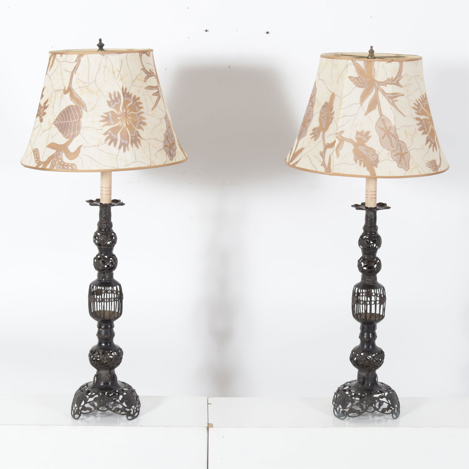 Pair Japanese Bronze Candle Stands as Lamps: Pair of Japanese pierced bronze baluster form candle stands as electrified table lamps with floral shade.Dimensions: Top of finial 43" x 8 1/2"W, shade 12 1/2 H x 18 W