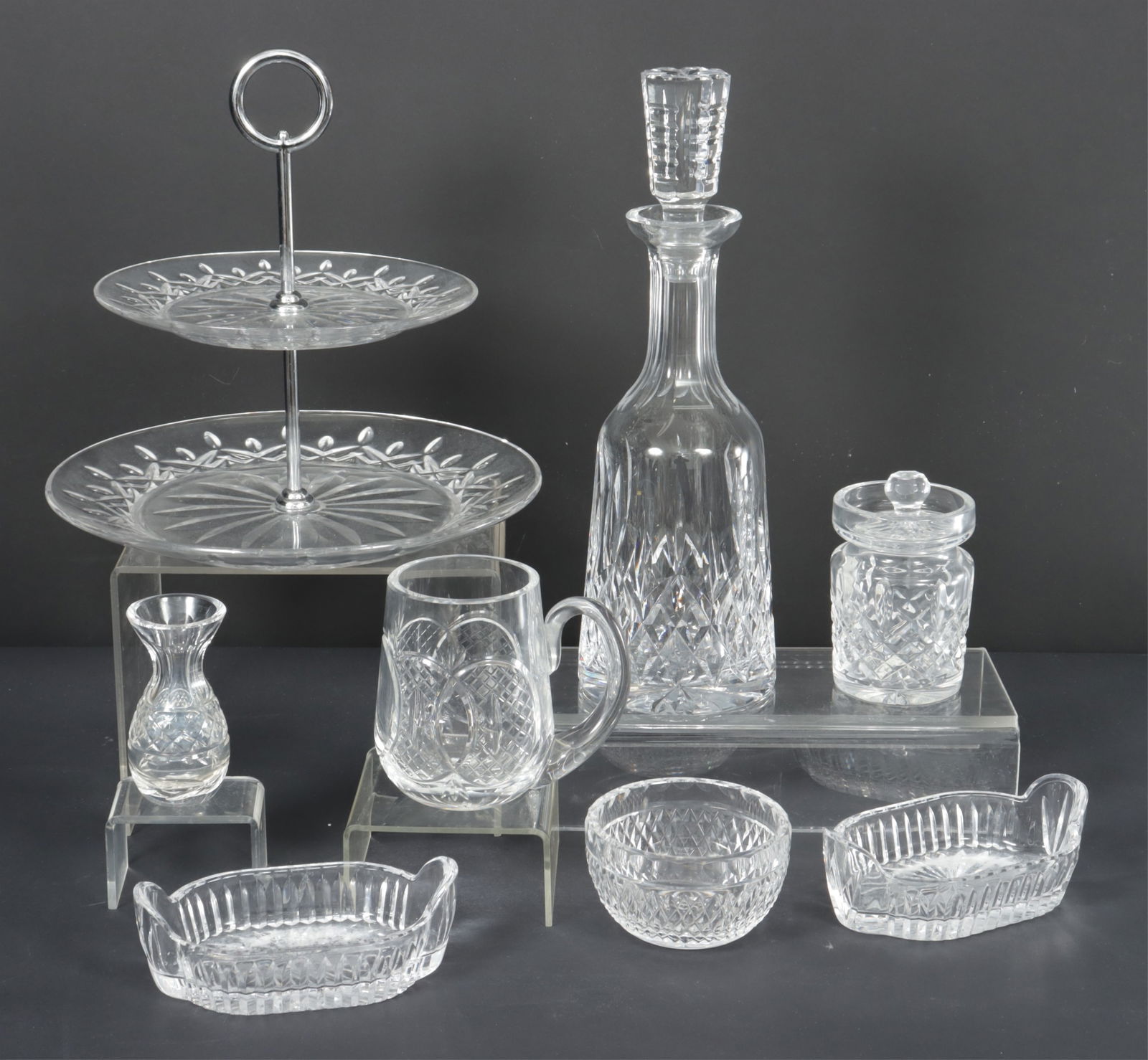 Group of Waterford Crystal Serving Pieces: Group of Waterford crystal serving pieces including a two-tier serving tray, decanter with stopper, covered vessel, small vase, pair of oblong vessels, small bowl, and handled jug.Dimensions: Decanter