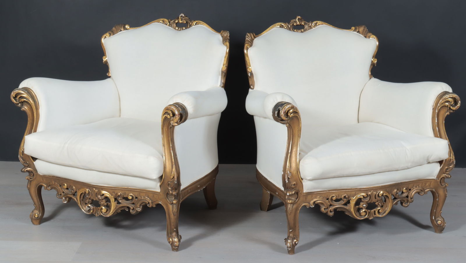 Pair Italian Rococo Style Giltwood Armchairs: Pair Italian Rococo style giltwood armchairs, with cream-colored muslin covering, trapezoidal squab cushion.Dimensions: 37" H x 36 1/2" W x 31" D