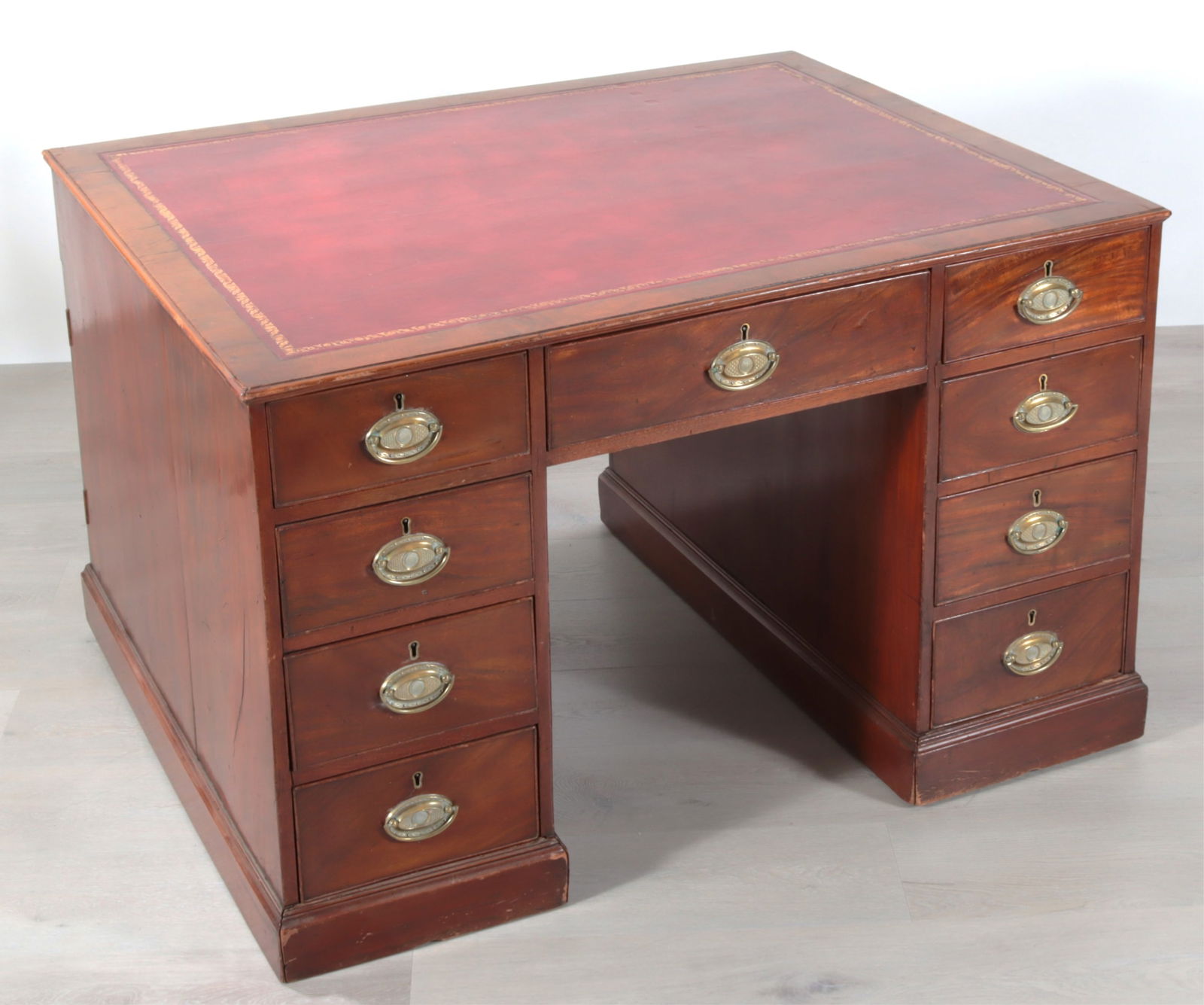 Regency Mahogany Pedestal Partner's Desk, 19th C.: Regency Mahogany Pedestal Partner's Desk, Early 19th C., with gilt tooled burgundy leather, raised on castersDimensions: 30.25" H x 47.75" W x 38.5" D
