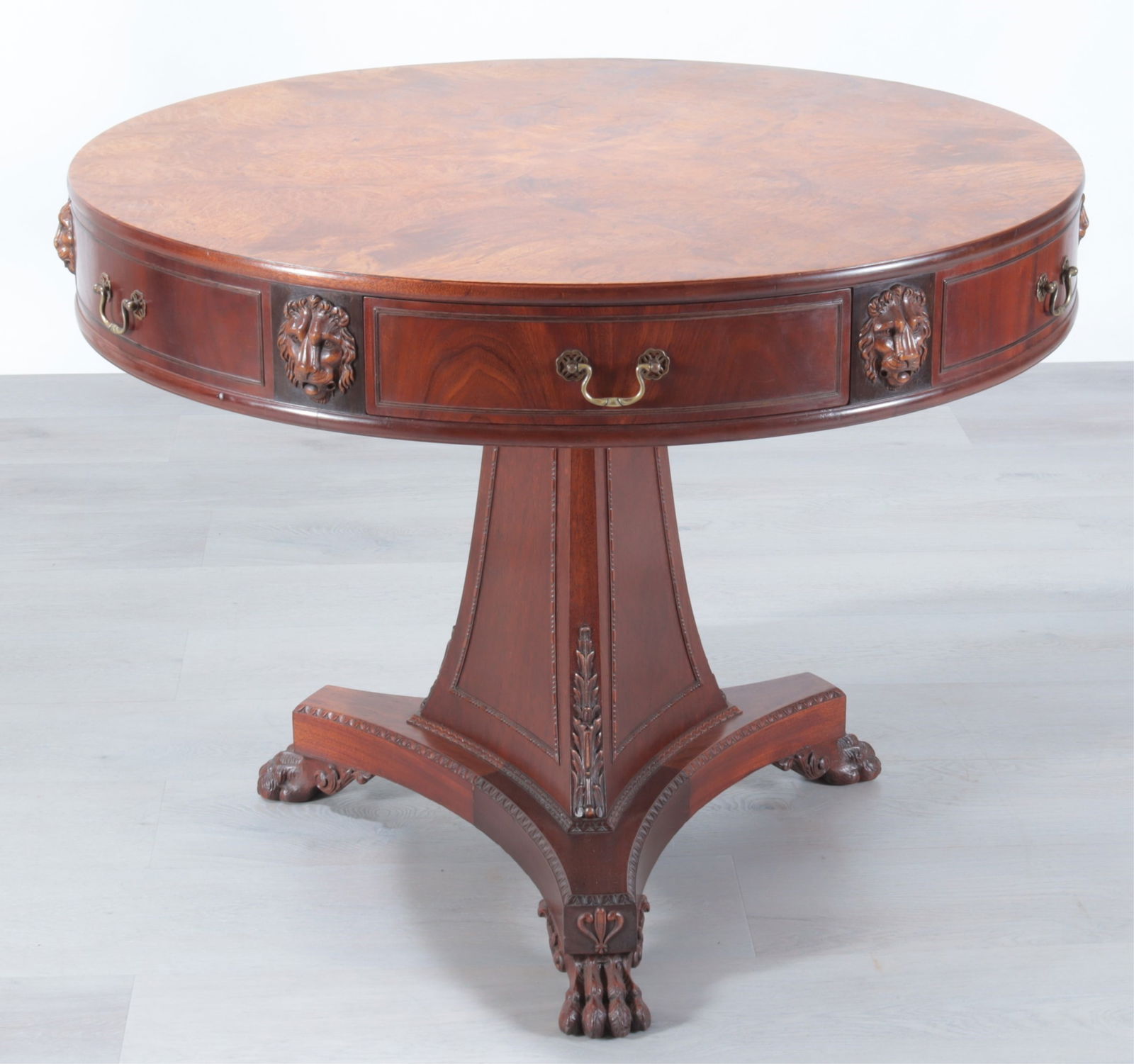 Regency Style Burlwood & Mahogany Drum Table: Joseph Gerte Furniture Company, Boston, Mass. Regency Style Burlwood & Mahogany Drum Table, carved with lion's mask.Dimensions: 29.5" H x 38.25" Dia.