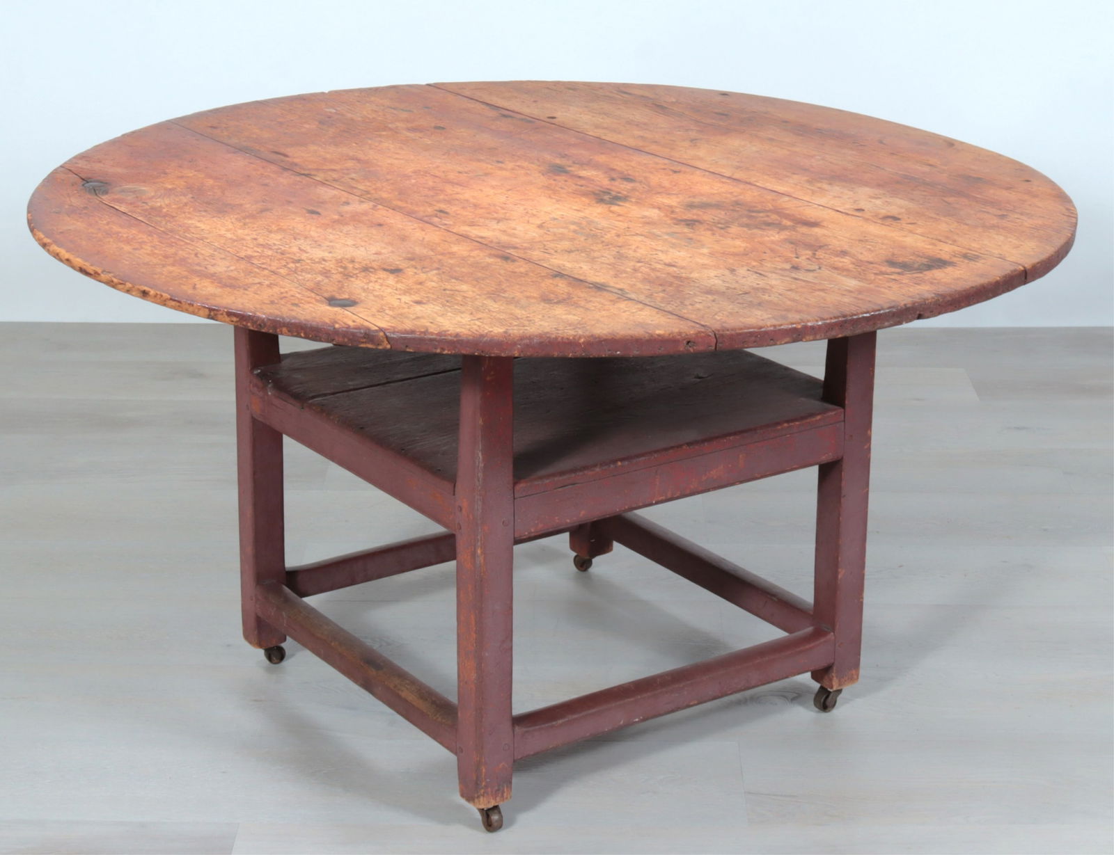 American Red Painted Chair Table: American Red Painted Chair Table, 19th Century, 3-board top, 2-board plank seat, with casters.Dimensions: 26 3/4" H x 50 3/4" W x 51" DProperty from the Estate of Isobel & Price Glover, Litchfield,
