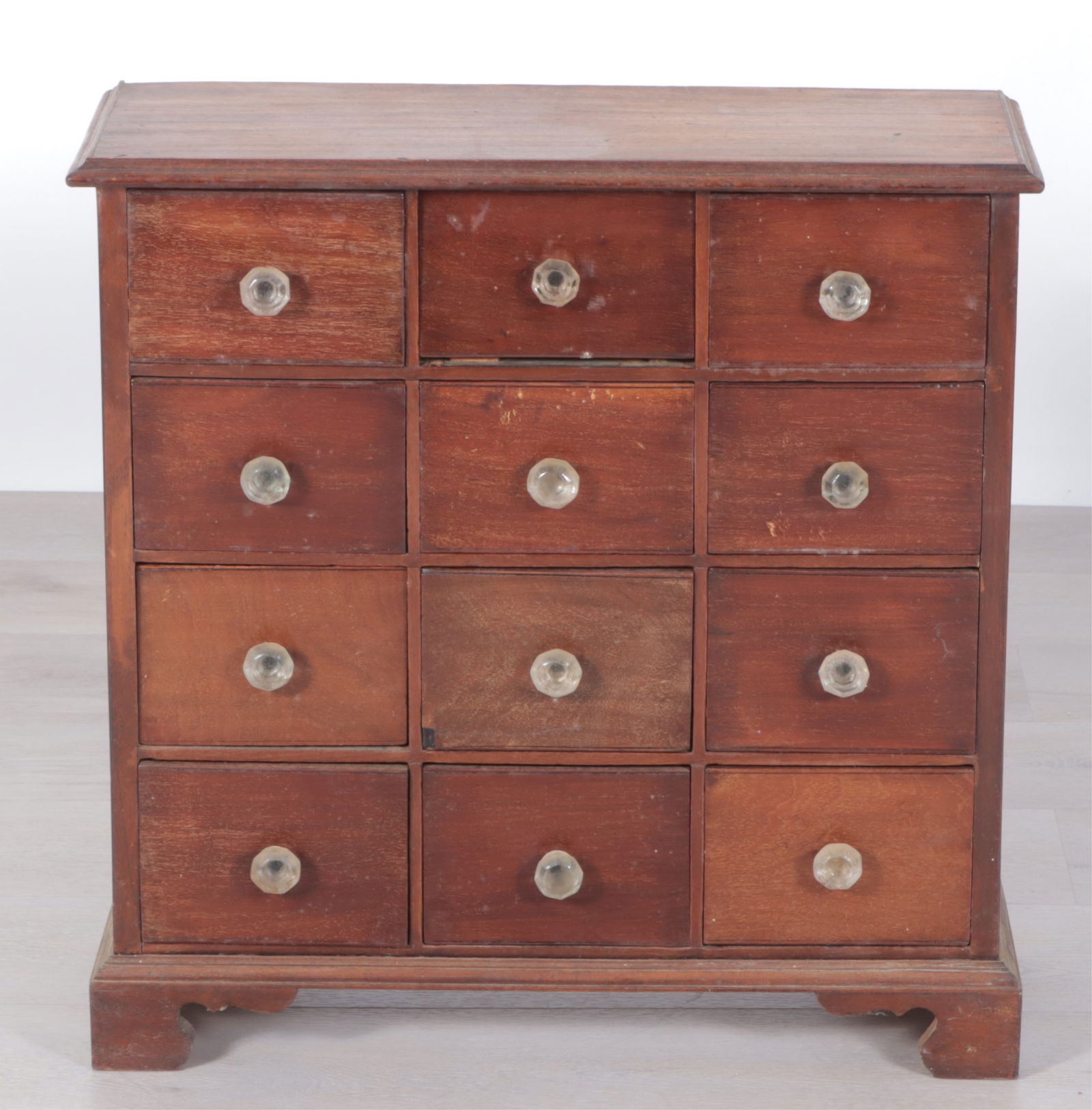 Country Stained Cherry 12-Drawer Apothecary: Country Stained Cherry 12-Drawer Apothecary with glass drawer pulls.Dimensions: 26.75" H x 26.25" W x 10" D