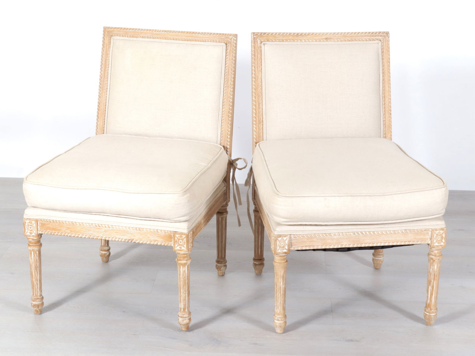 Pair of Louis XVI Style Slipper Chairs: Pair of Louis XVI Style Slipper Chairs. Bleached oak frames, upholstered in beige linen.Dimensions: 34.5" H x 21.5" W x 26" D