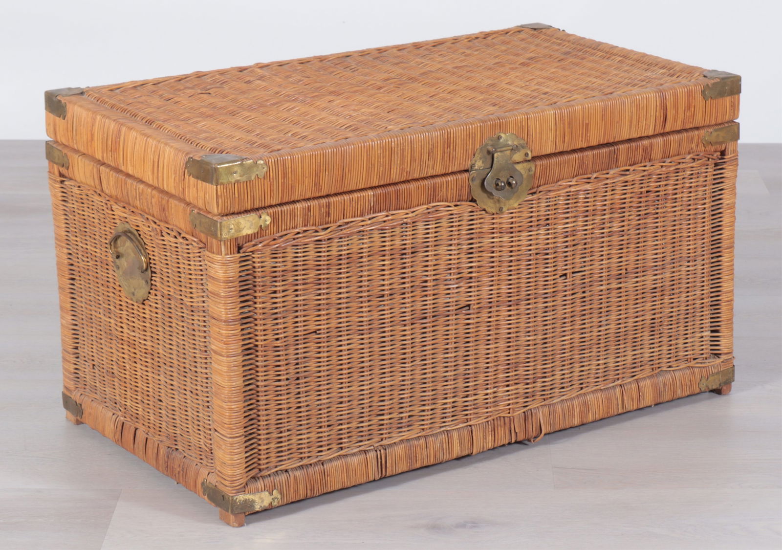 Antique Rattan Trunk 19th C: Antique rattan trunk, 19th Century, with engraved latch and corner mounts; fitted with side handles.Dimensions: 20" H x 35 3/4" W x 20" D
