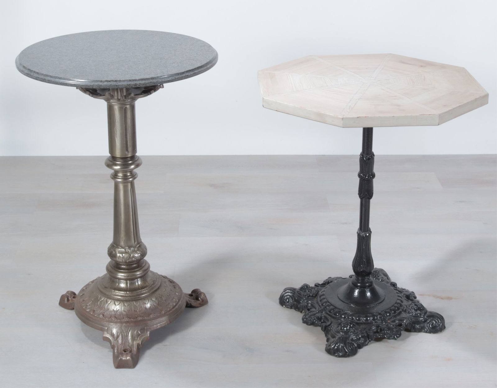 Cast Iron Cafe and Bistro Pedestal Tables: Two cast iron tables, one black painted bistro table with grey washed wooden octagonal table top another classical style cafe table, pedestal base with installation holes on feet, round granite round