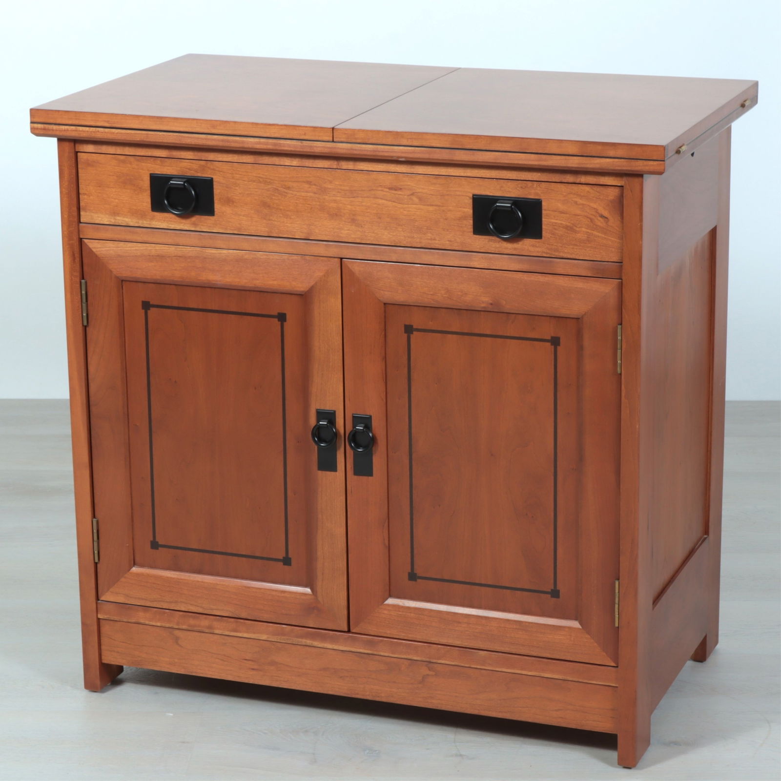 Stickley Arts Crafts Mahogany Fold Top Bar: Stickley Arts & Crafts Style mahogany bar cabinet, 20th Century, with folding top with black laminate surface, long drawer over two cabinet doors, adjustable shelved interior, ebonized ring