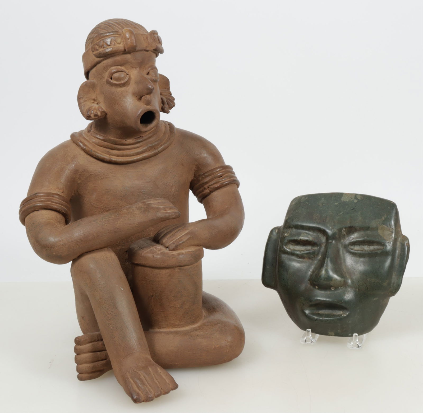 Pre-Columbian Style Figure and Stone Mask: 20th century Pre-Columbian West Coast Nayarit style seated ceramic figure, together with an earlier Olmec style carved stone mask, likely green jasper. Dimensions: Figure 16 H x 11.5" W. Mask 7.5" H