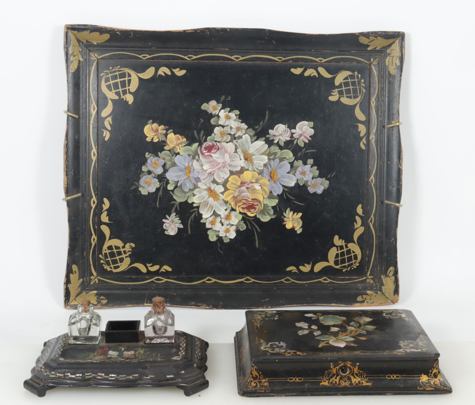 Victorian Mother of Pearl Black Lacquer Tableware: A grouping of Victorian black lacquer tableware with Mother of Pearl inlay. Comprising: large tray with painted floral decoration, desk tray with ink wells, and covered box. Dimensions: Large tray