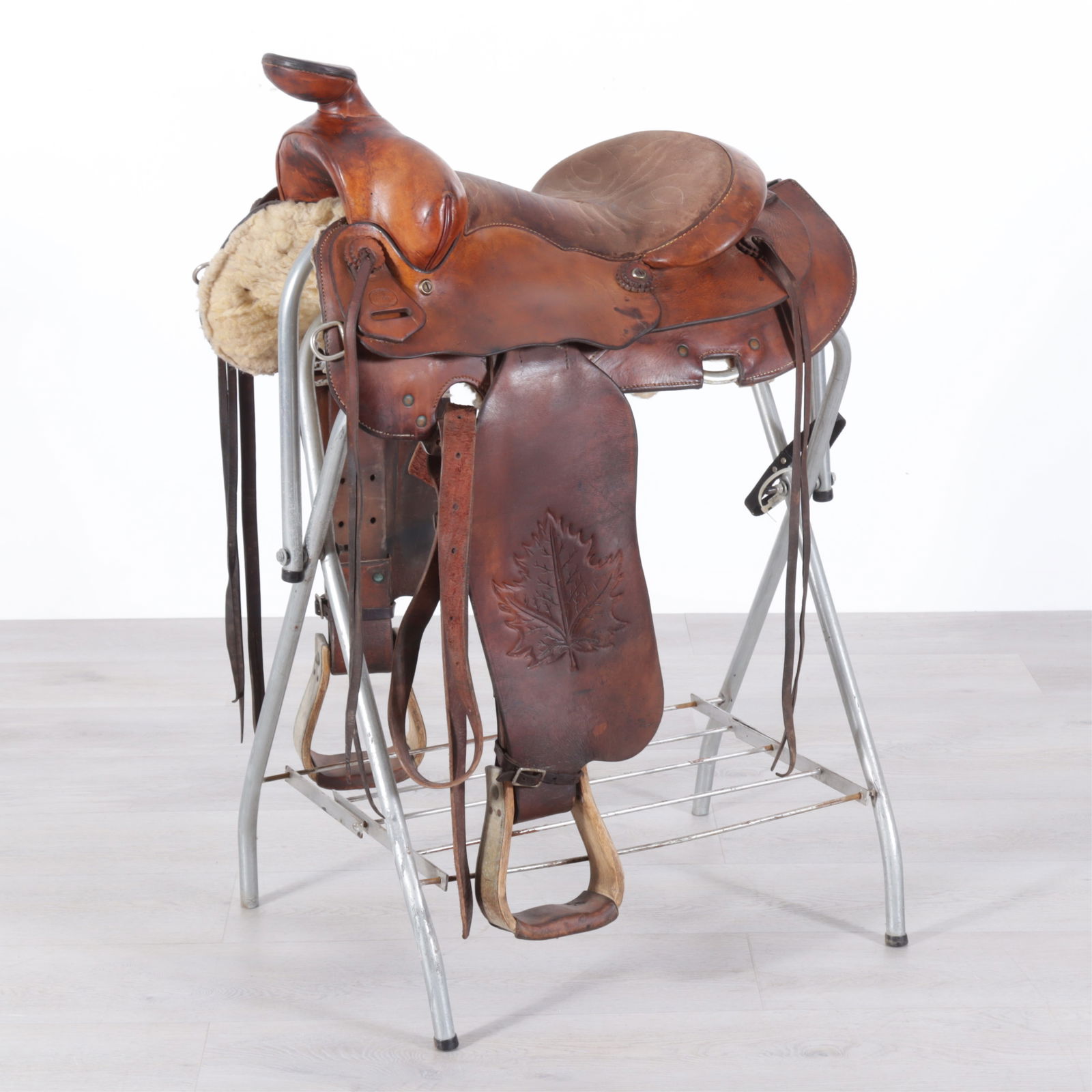 F. Eamor Canadian Centennial Saddle 1867-1967: F. Eamor Canadian Centennial horse saddle on stand, rawhide, leather & wood on metal stand. Note: Limited edition saddles made for the Canadian Centennial built on a low moose tree, 7/8 double shirt