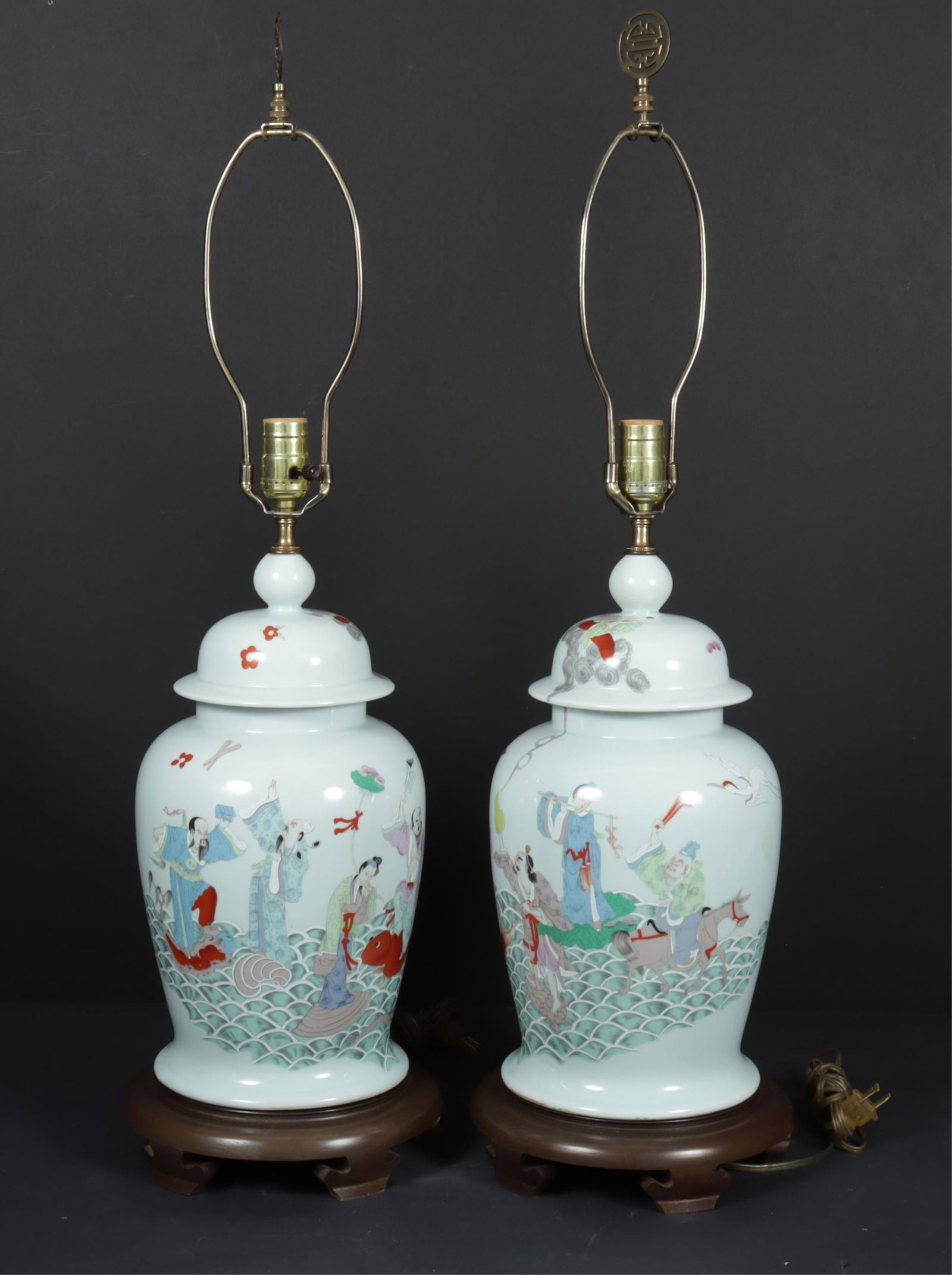 Pair of Chinese Style Ginger Jar Lamps: A pair of Chinese style ginger jar form lamps. Pale celadon ground with figural scenes on wooden bases. Late 20th century. Dimensions: Vase 16" H, overall 22" high to the fixture. 