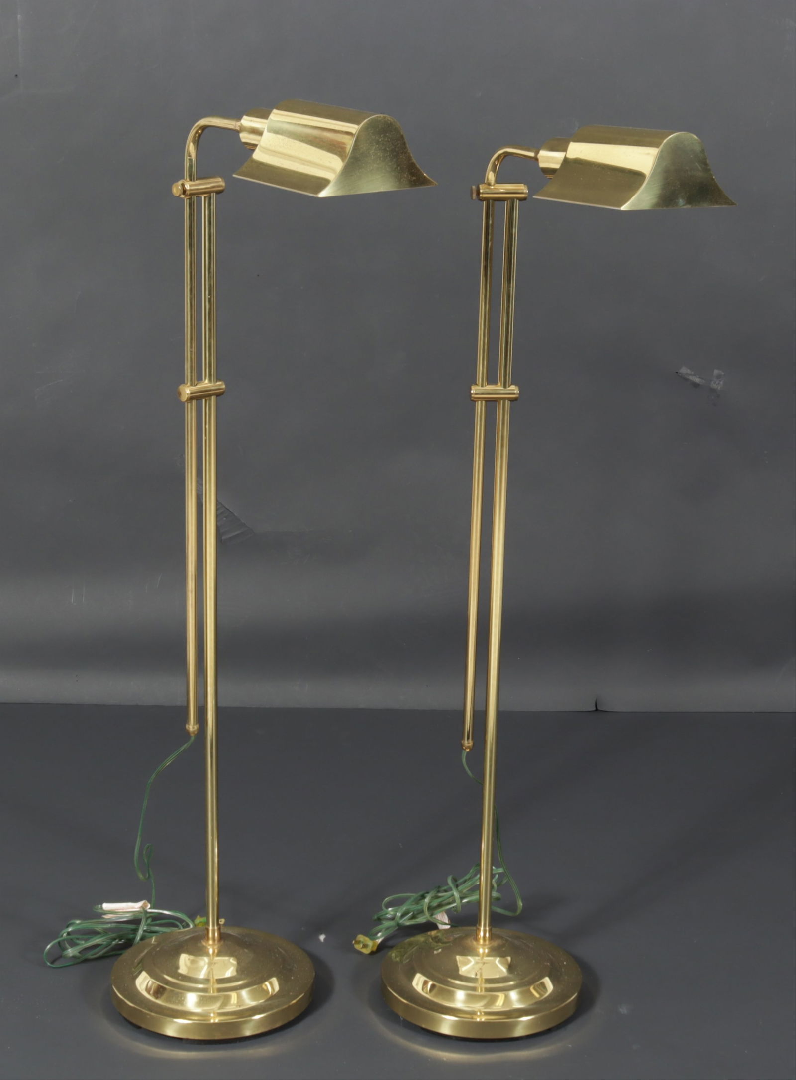 Pair Contemporary Brass Reading Lamps: Pair of Contemporary Brass Reading Lamps. Adjustable height with round bases. Dimensions: Lowest 44" H 
