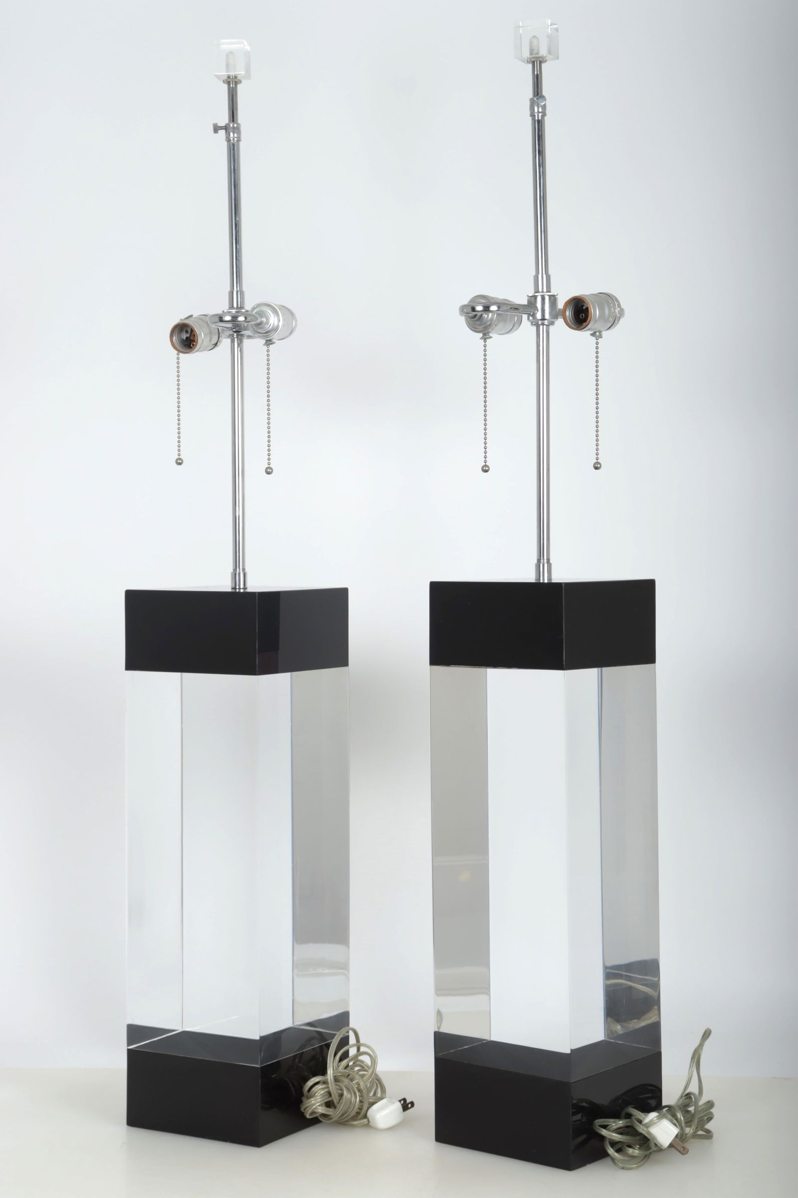 Pair Alessandro Albrizzi Design Table Lamps: Pair of Alessandro Albrizzi Design table lamps, c.1999, clear and black lucite, clear lucite cube finial. Dimensions: 38 1/2 x 41 1/2 H (adjustable stem) x 6 square Property of a New York Architect
