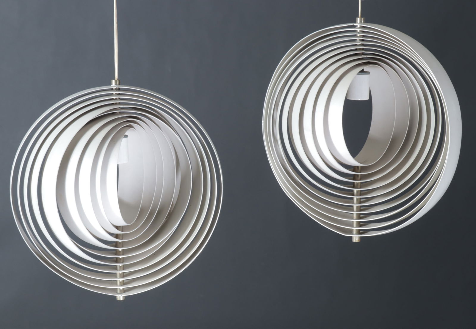 Pair of Verner Panton Pendant Moon Lamps: Pair Verner Panton pendant "Moon" lamps, each outer frame fitted with 9 nesting pivoting ribs, white enamel socket covers, no visible stamps, marks or labels Dimensions: Outer frame: 14 1/2" H x 13