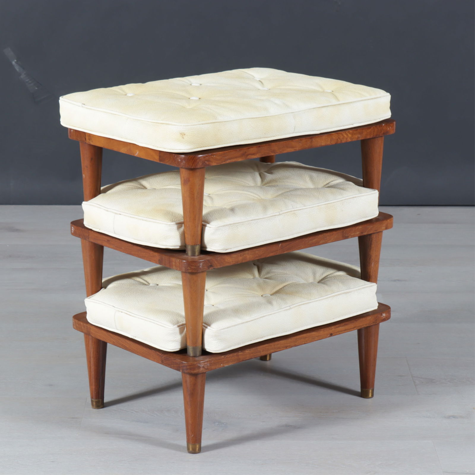 Hayat Bros Teak Stacking Benches, c.1960: Three Mid-Century Hayat Bros Teak Stacking Benches, circa 1960, labeled with metal tag, in off-white leatherette upholstery. Dimensions: Each 9.5" H x 19.25" W x 14' D 