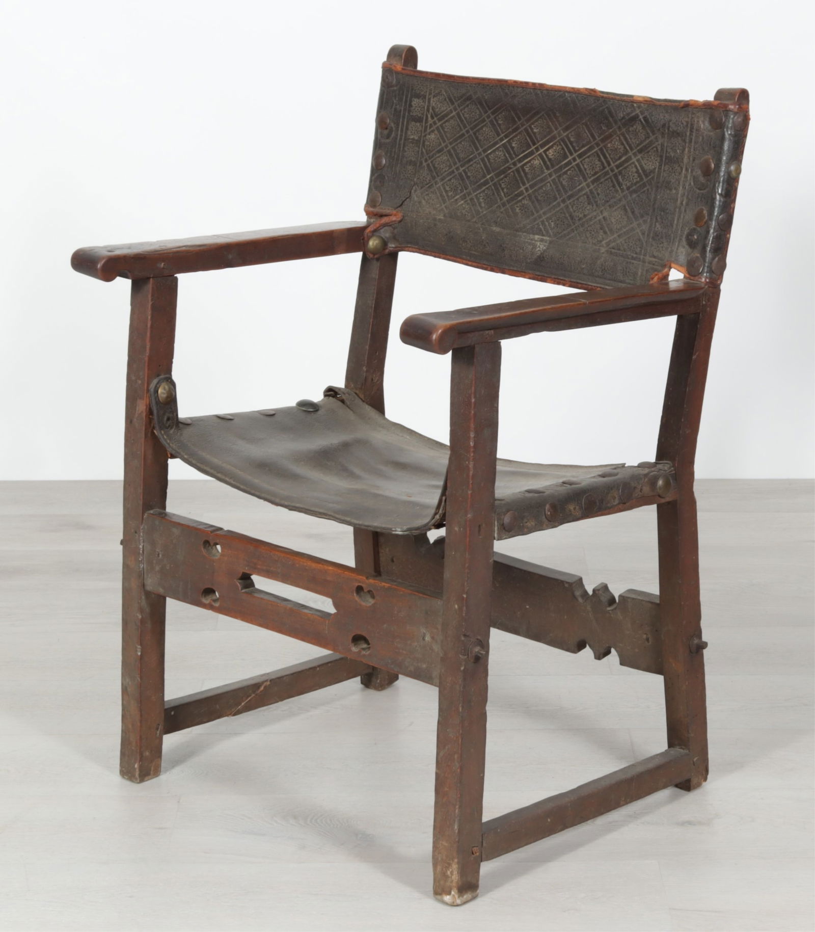 Spanish Baroque Walnut Armchair, 17th C.: Spanish Baroque Walnut Armchair, Late 17th C., black leather sea and embossed back rest. Dimensions: 37.25" H x 25" W x 22" D 