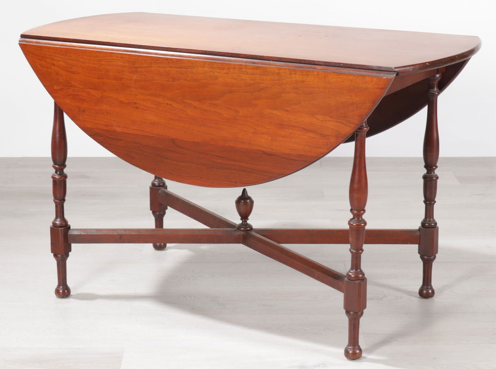 Colonial Style Walnut Dropleaf Table: Colonial Style Walnut Dropleaf Table. Top with bowed ends and dumilune leaves, raised on baluster turned legs, with x-from stretcher. Dimensions: 29" H x 22.75" W x 48" D 